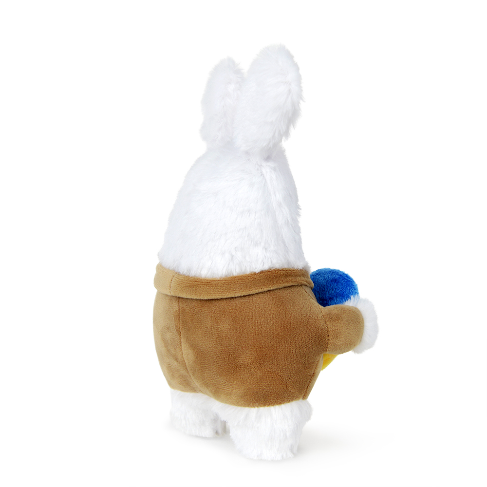 Ein weißes Plüschkaninchen mit brauner Jacke, das ein blaues und gelbes Objekt hält. Isoliert auf weißem Hintergrund.