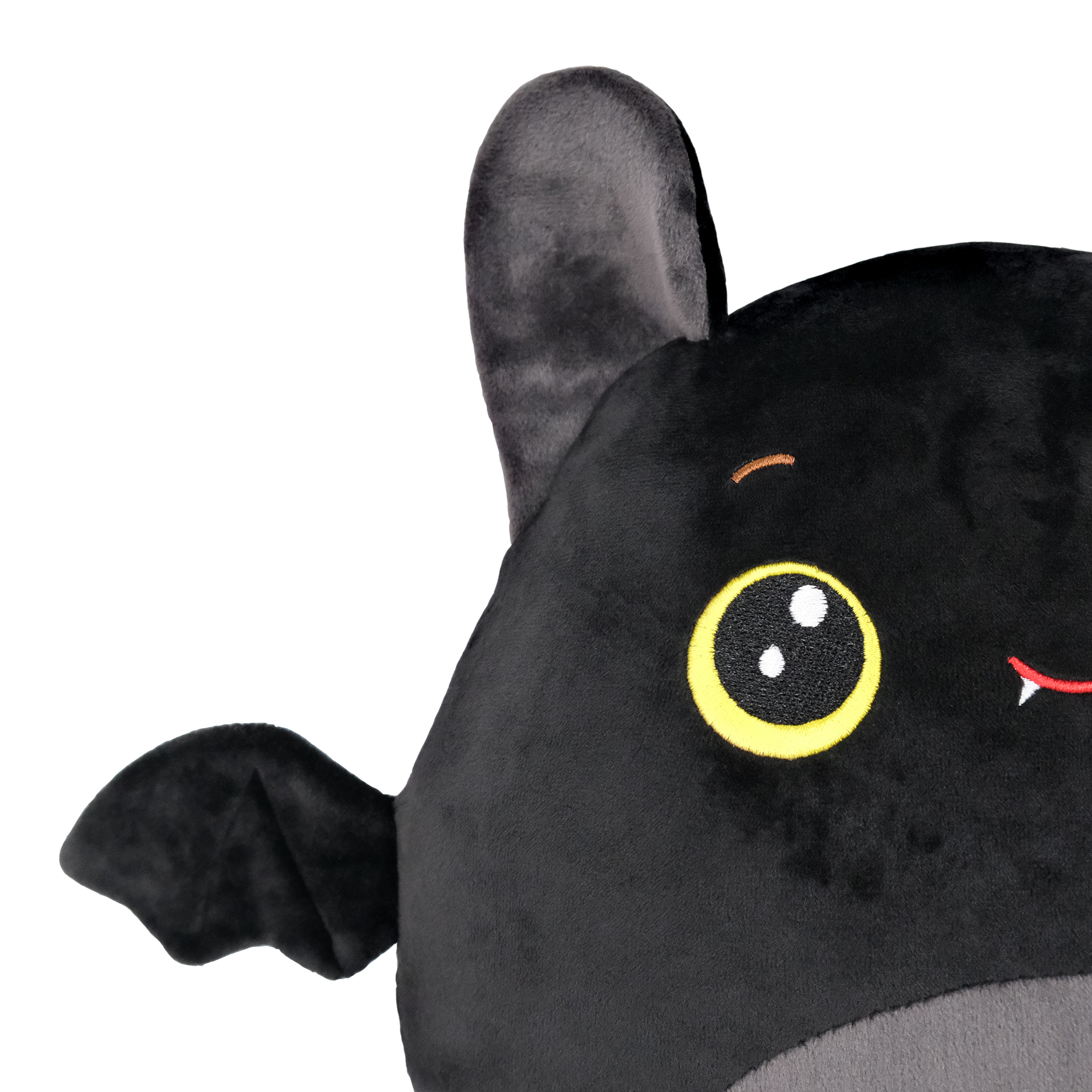 Schwarzes Plüsch-Fledermaus-Spielzeug mit gelben Augen, kleinem Lächeln und Fledermausflügel. Der Hintergrund ist weiß.