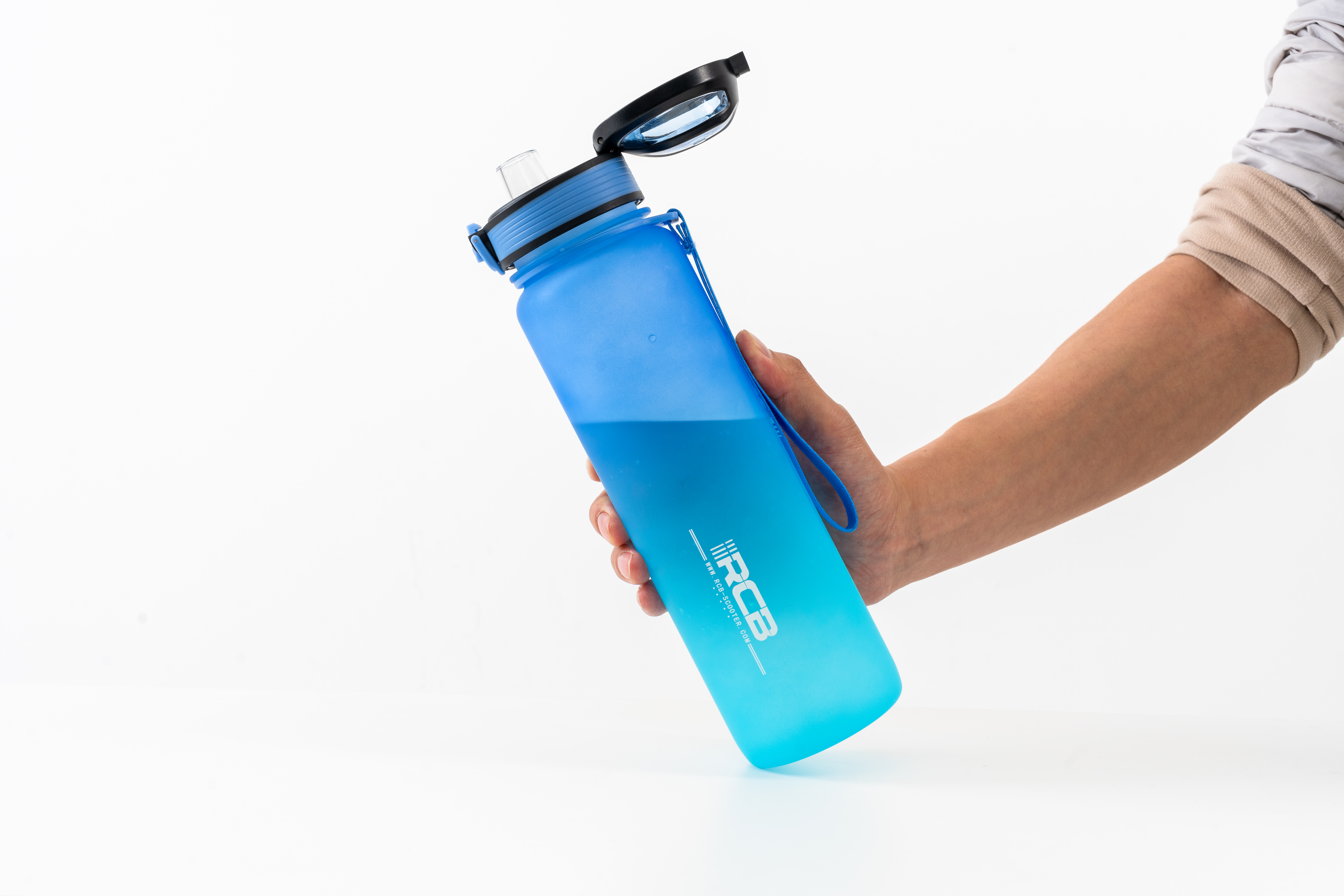 Eine Hand hält eine blaue Wasserflasche vor weißem Hintergrund. Der Deckel ist offen.