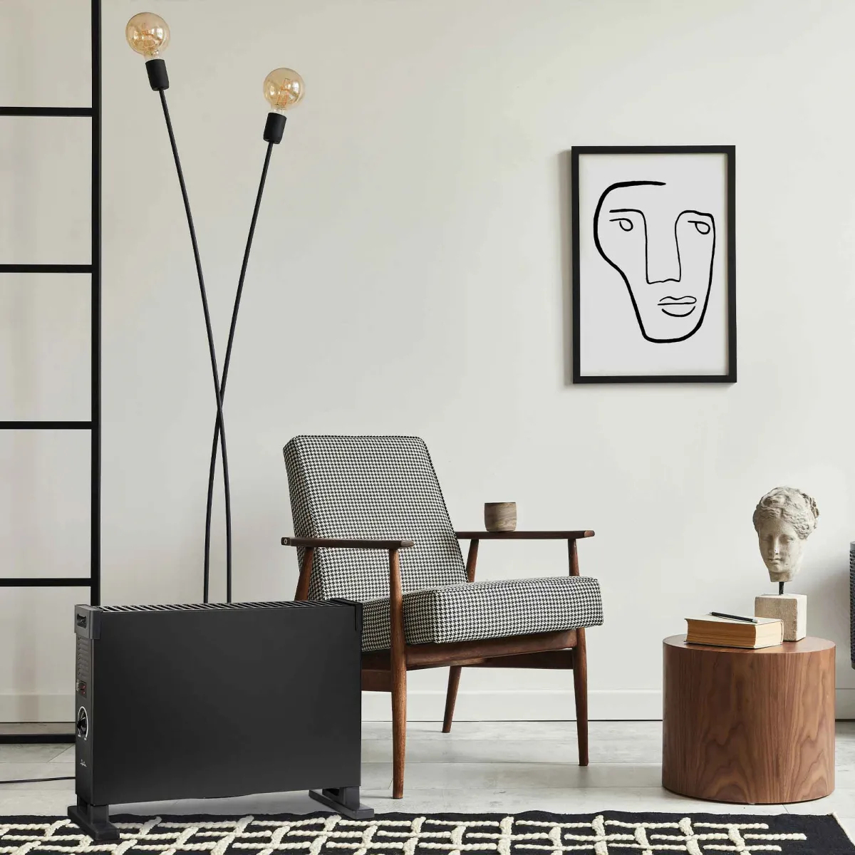 Una habitación con un calefactor negro, una silla de pata de gallo, una lámpara, un cuadro, una mesa auxiliar y una alfombra.