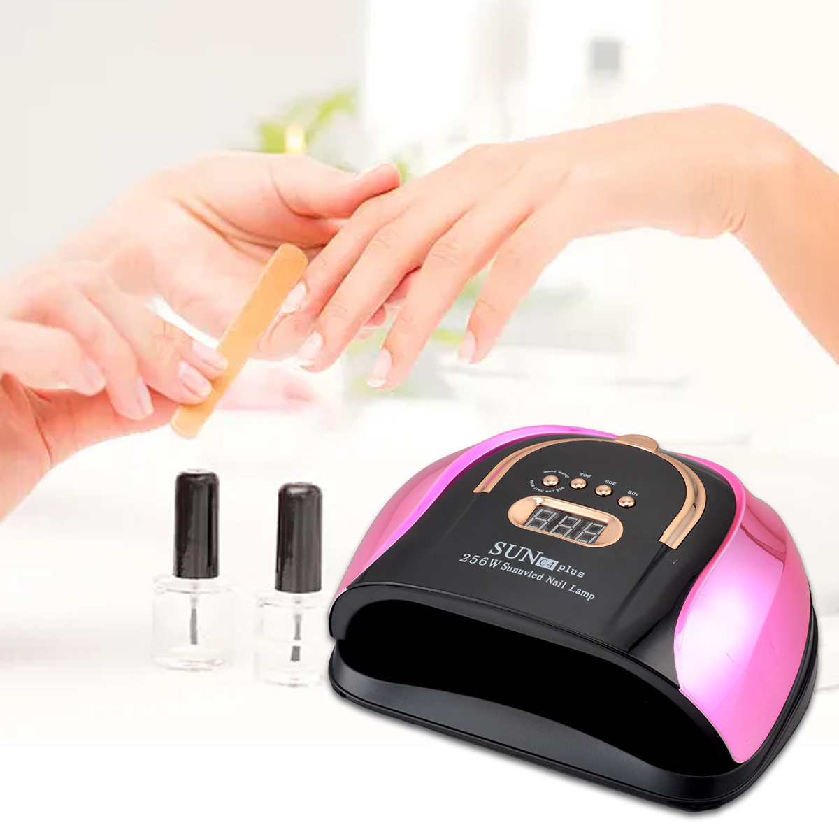 Eine Nageldesignerin feilt die Nägel einer Kundin. Eine rosa-schwarze UV-Nagellampe und zwei Nagellackflaschen sind im Bild.