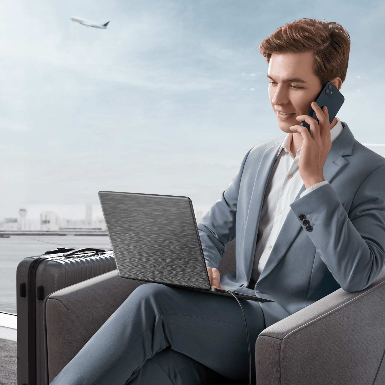 Hombre en traje hablando por teléfono, usando portátil en el aeropuerto. Avión en el cielo, maleta al lado.