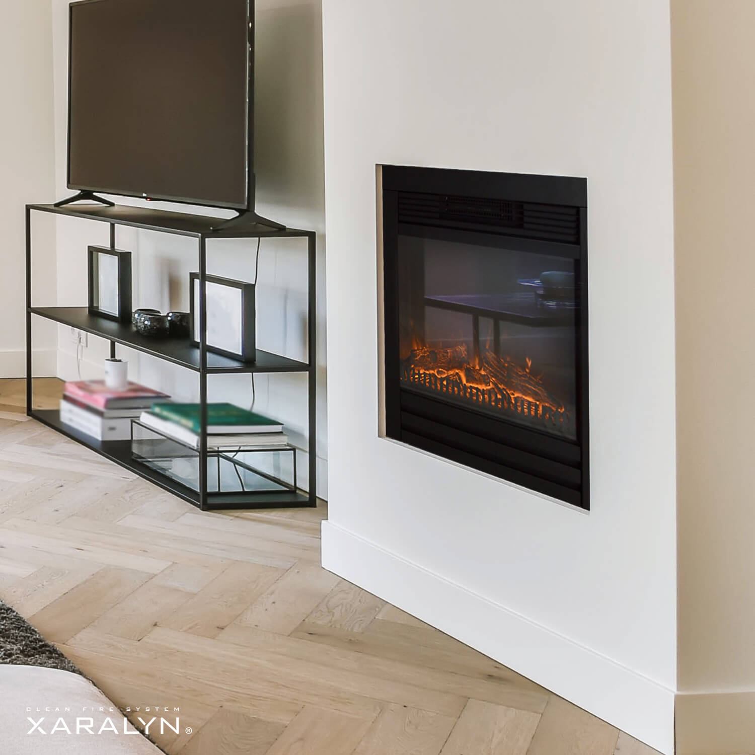 Moderne woonkamer met open haard, tv en zwarte metalen planken. De vloer is licht houten visgraat.