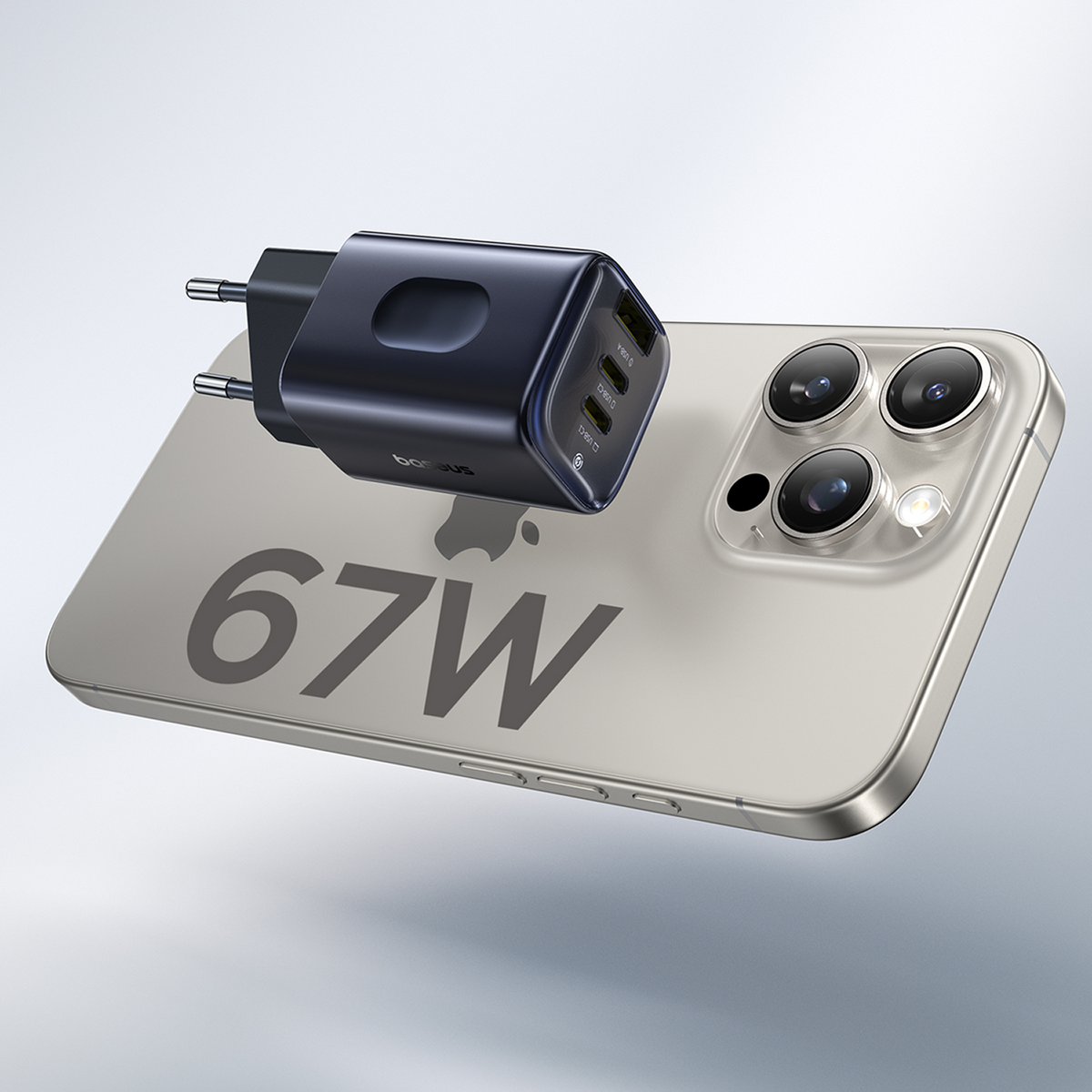 Een zwarte oplader ligt op een telefoon. De telefoon heeft drie cameralenzen. Op de telefoon staat 67W.