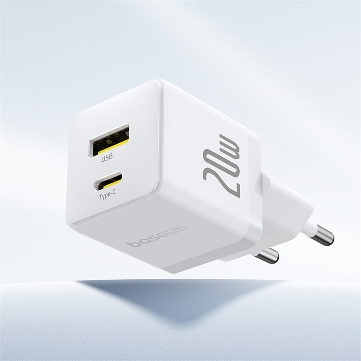 Un caricabatterie Baseus bianco da 20W. Ha porte USB e di tipo C e una spina a due poli. Lo sfondo è una sfumatura di bianco.