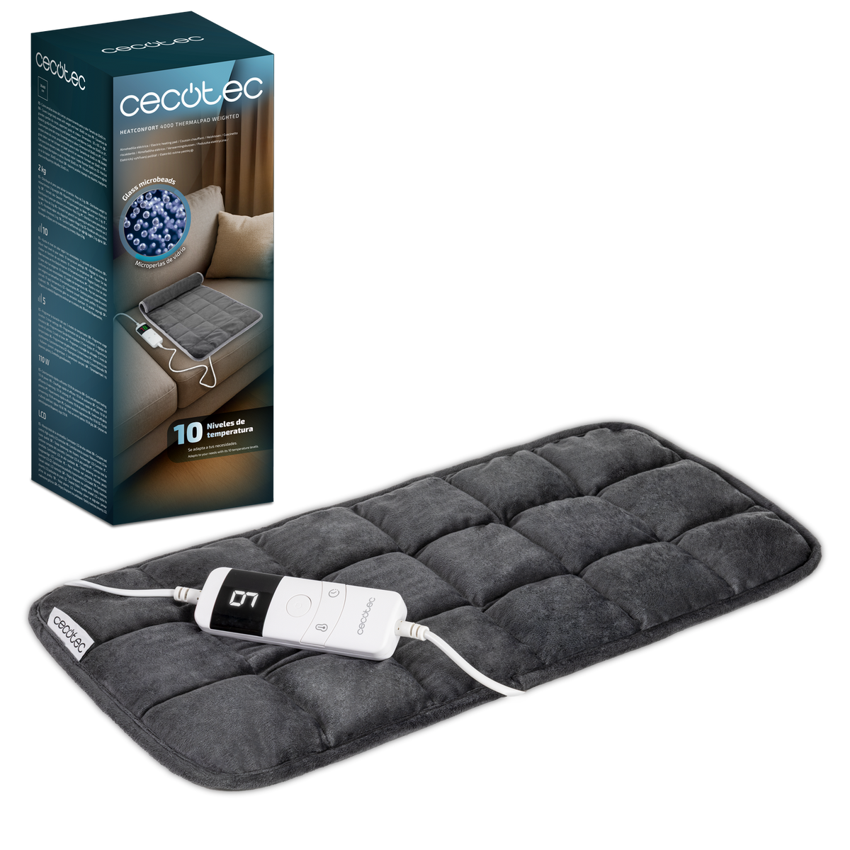 Una almohadilla térmica gris con un panel de control y una caja del producto. La almohadilla está sobre una superficie negra. La caja describe el producto.