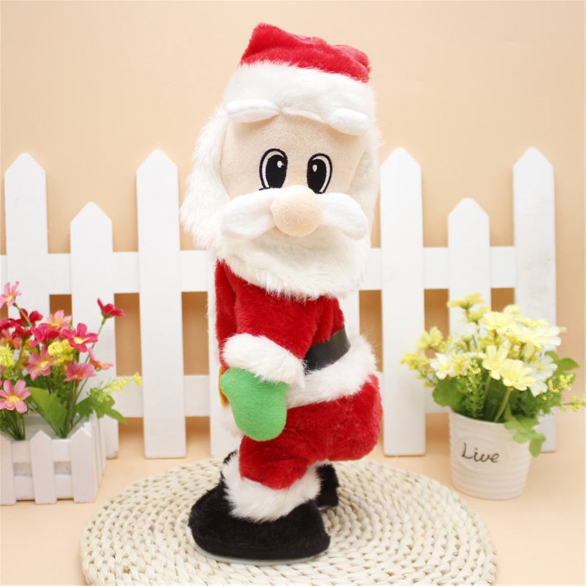 Eine Weihnachtsmann-Puppe mit rotem Anzug, weißem Bart und Hut, schwarzen Stiefeln und grünen Handschuhen steht auf einer gewebten Matte mit Blumen.