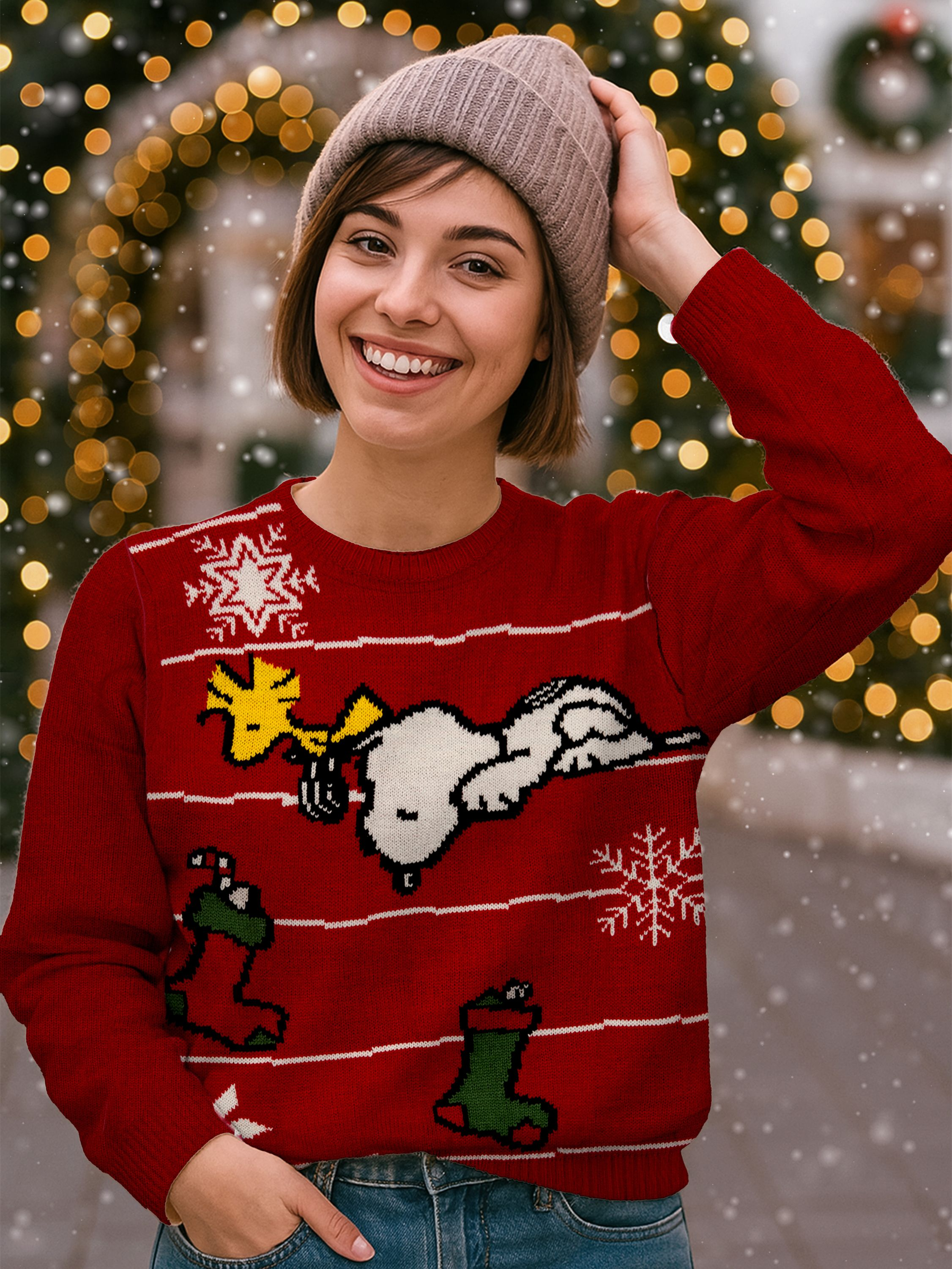 Eine lächelnde Frau trägt einen roten Snoopy-Weihnachtspullover und einen beigen Hut. Hintergrund mit Bokeh-Lichtern.