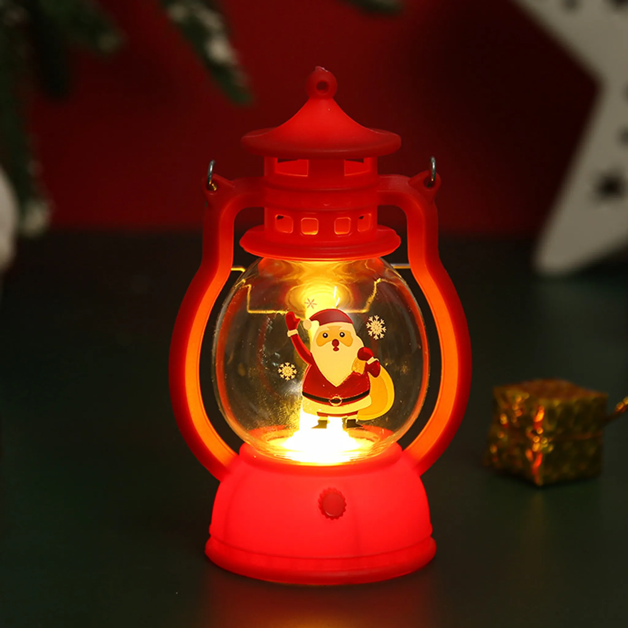 Rote Weihnachtslaterne mit Weihnachtsmann. Glühendes Licht. Grüner und roter Hintergrund. Goldenes Geschenk.