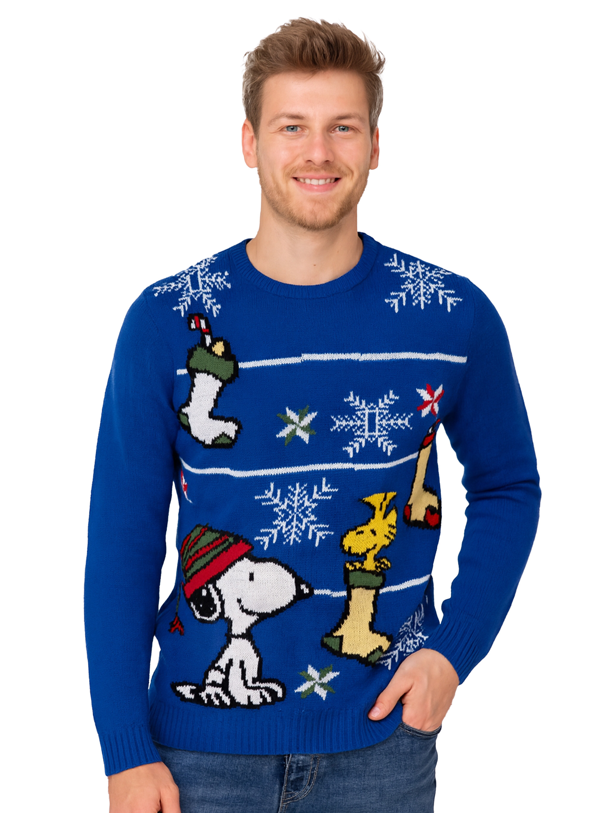 Mann trägt blauen Weihnachtspullover mit Snoopy- und Woodstock-Designs, lächelt. Jeans sind sichtbar.