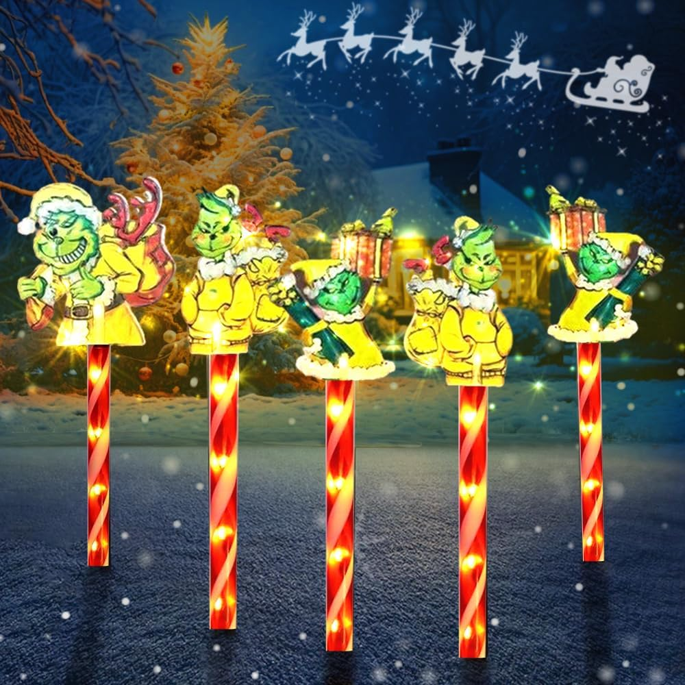 Weihnachtsszene mit Grinch-Figuren auf beleuchteten Pfählen. Santa fliegt über einer verschneiten Landschaft mit einem beleuchteten Weihnachtsbaum.