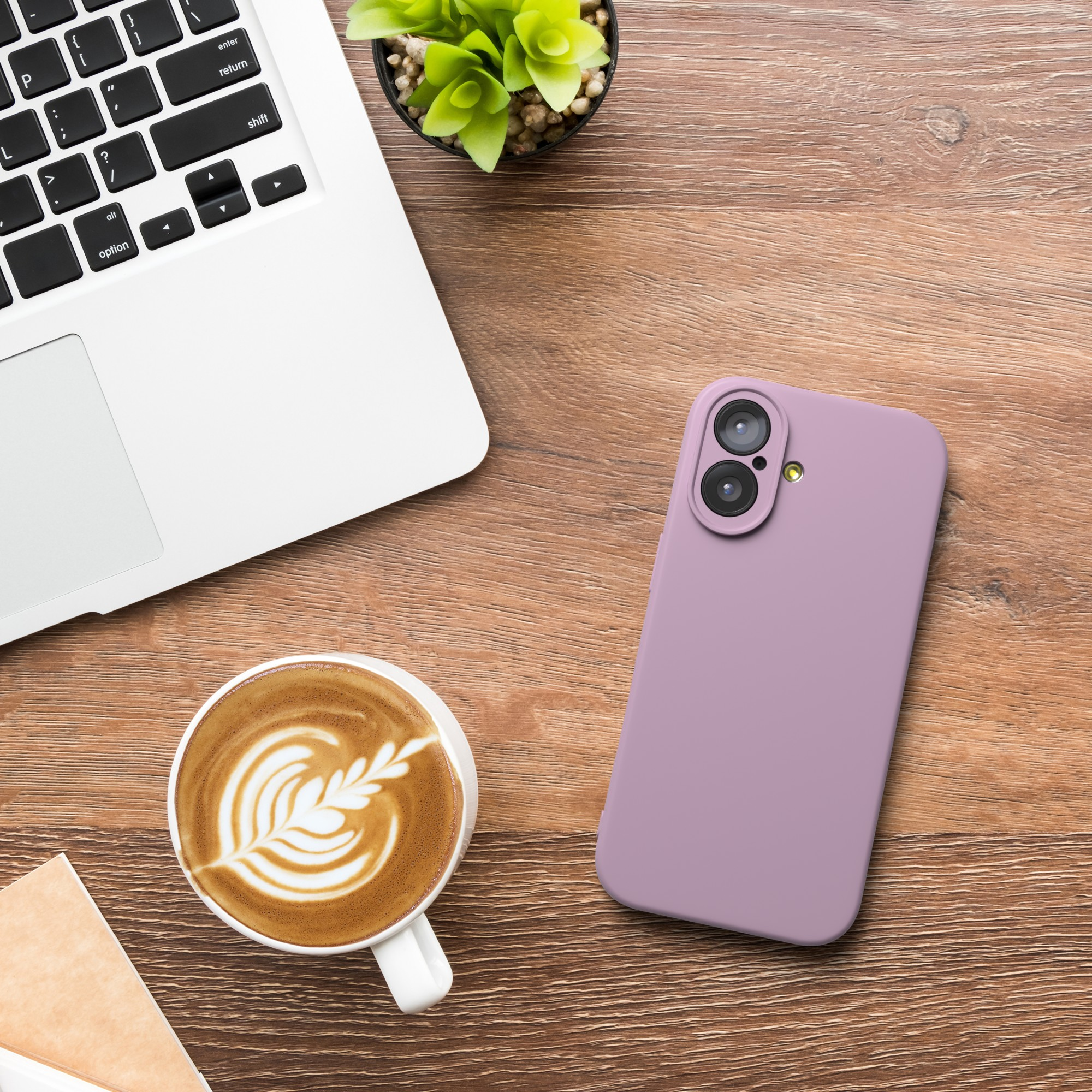 Laptop, Kaffee mit Latte Art, Telefon und Pflanze auf Holzoberfläche.