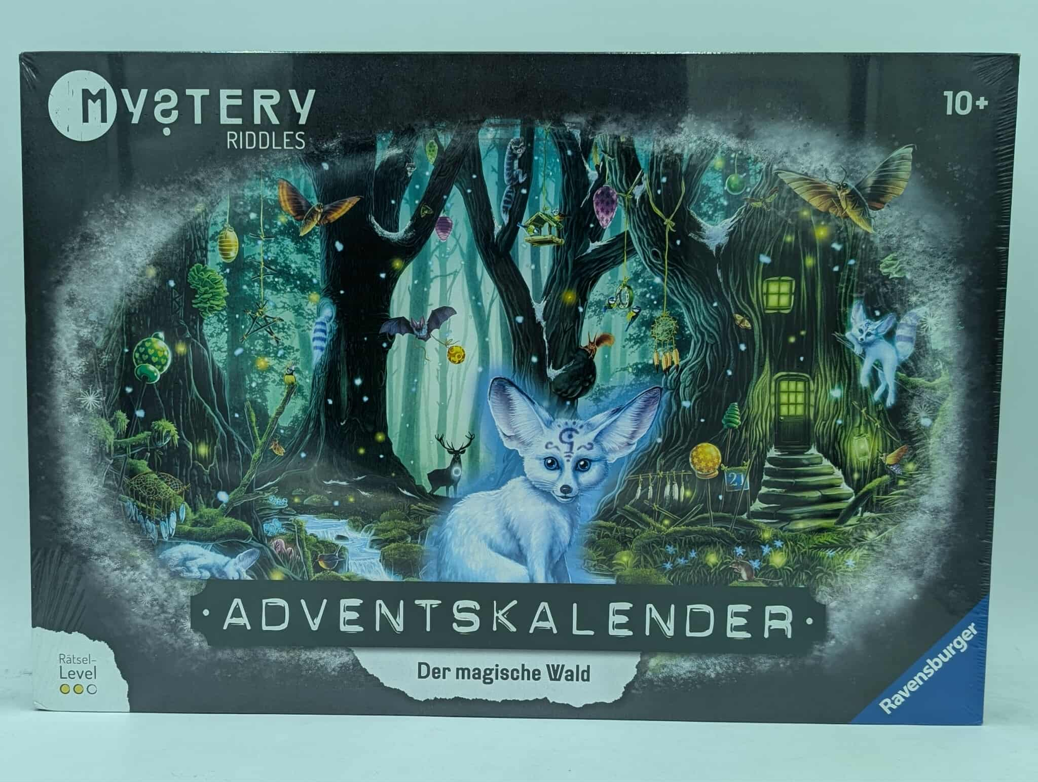 Schachtelkunst für ein Spiel. Ein weißer Fuchs mit großen Ohren befindet sich in einer magischen Waldszene mit einem Haus und Schmetterlingen.
