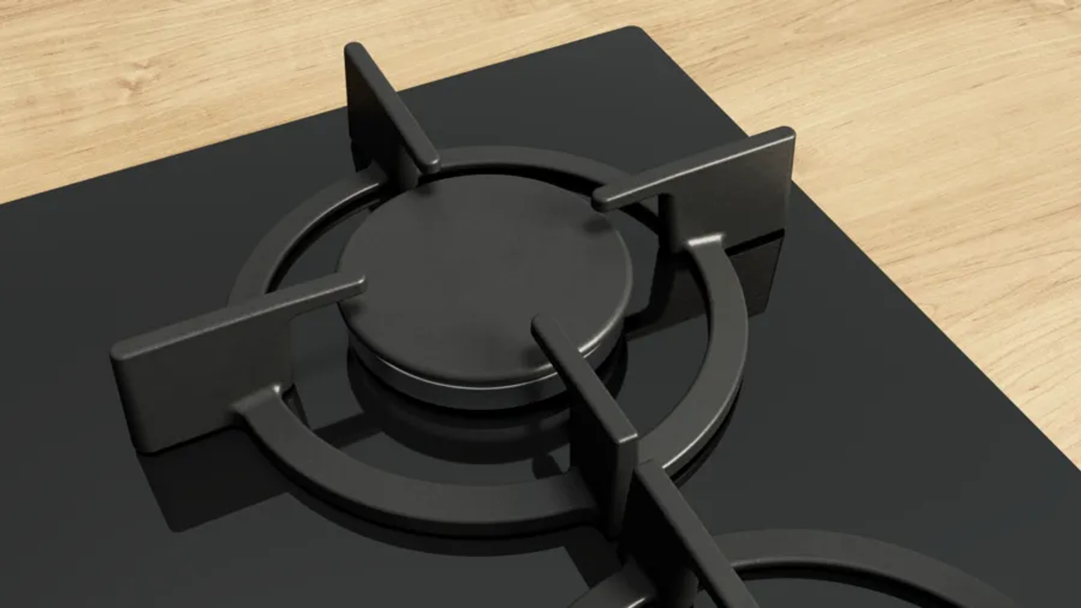 Zbliżenie czarnej płyty grzejnej z palnikiem. Tło przedstawia drewnianą powierzchnię.