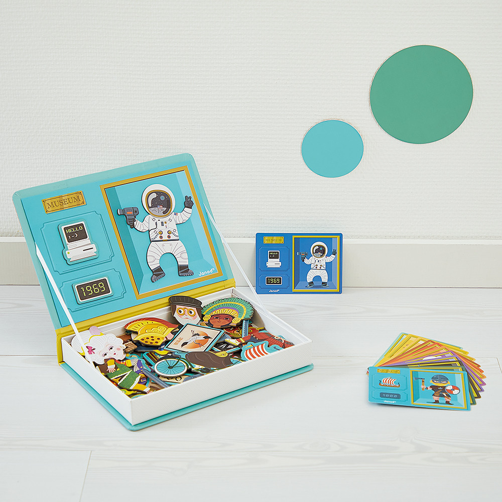 Un set di giocattoli a tema museo. Contiene una scatola a forma di libro, carte e figure. La scatola mostra un astronauta e un computer.
