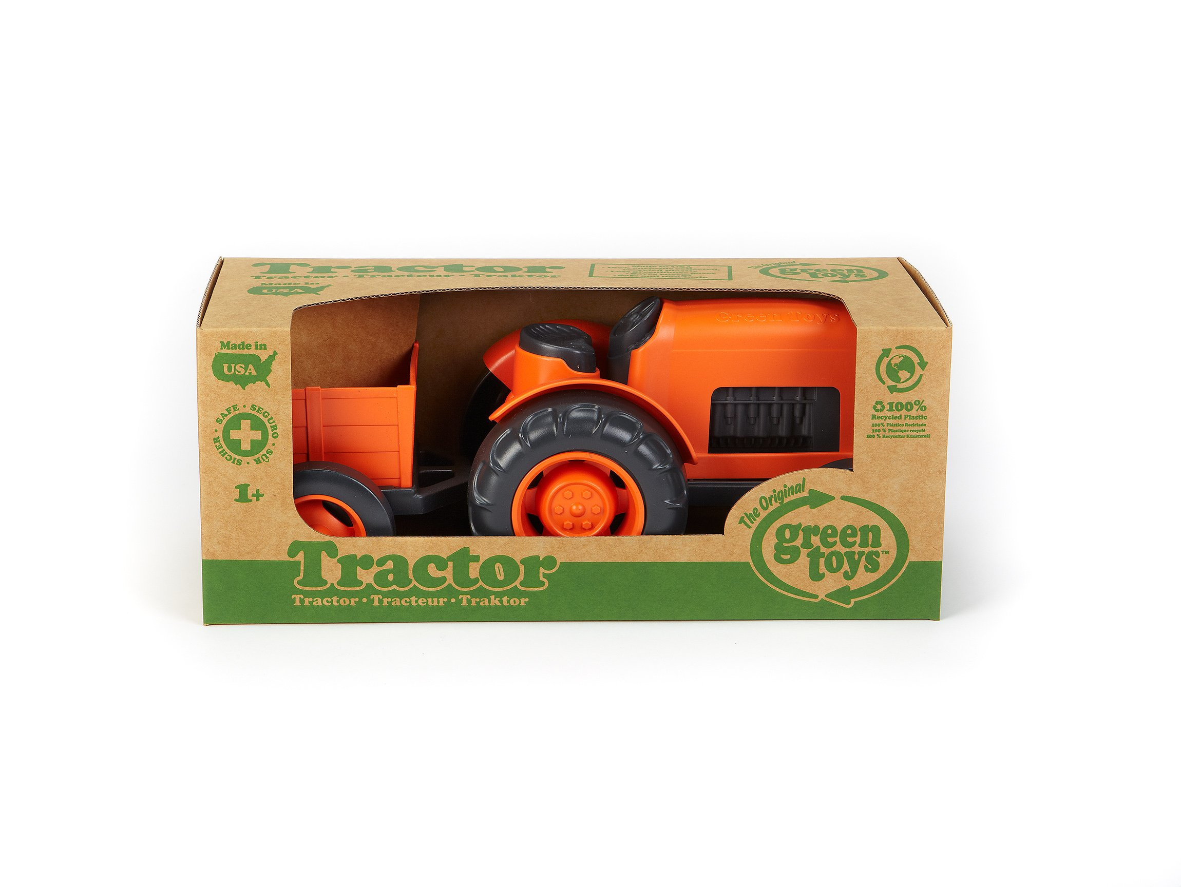 Pomarańczowy traktor Green Toys w kartonowym pudełku. Pudełko ma tekst i symbol recyklingu. Traktor jest wyprodukowany w USA.