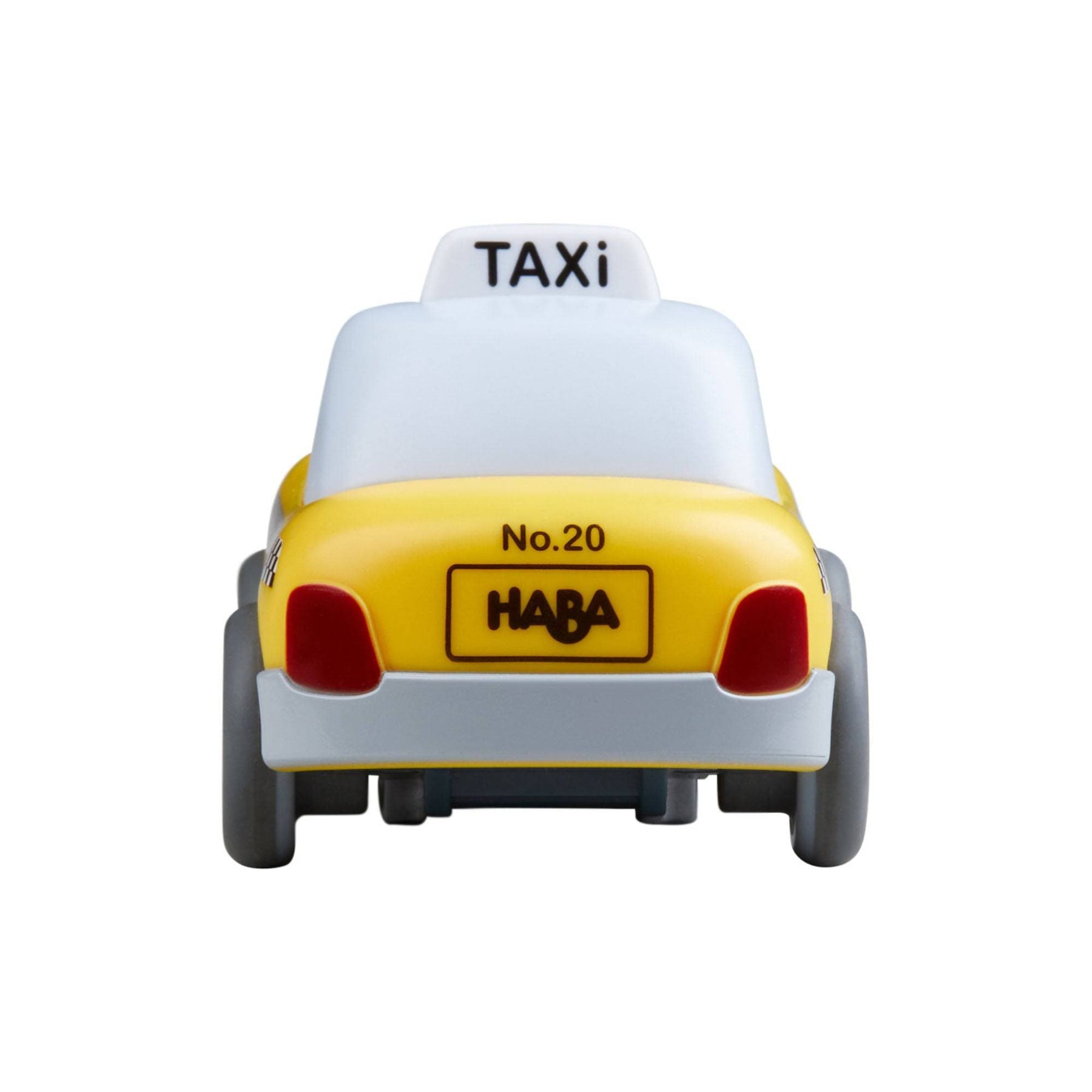 Ein gelbes Spielzeugtaxi mit weißem Dach, auf dem "TAXI" steht. Es hat rote Rücklichter und den Namen "HABA" auf dem Nummernschild.