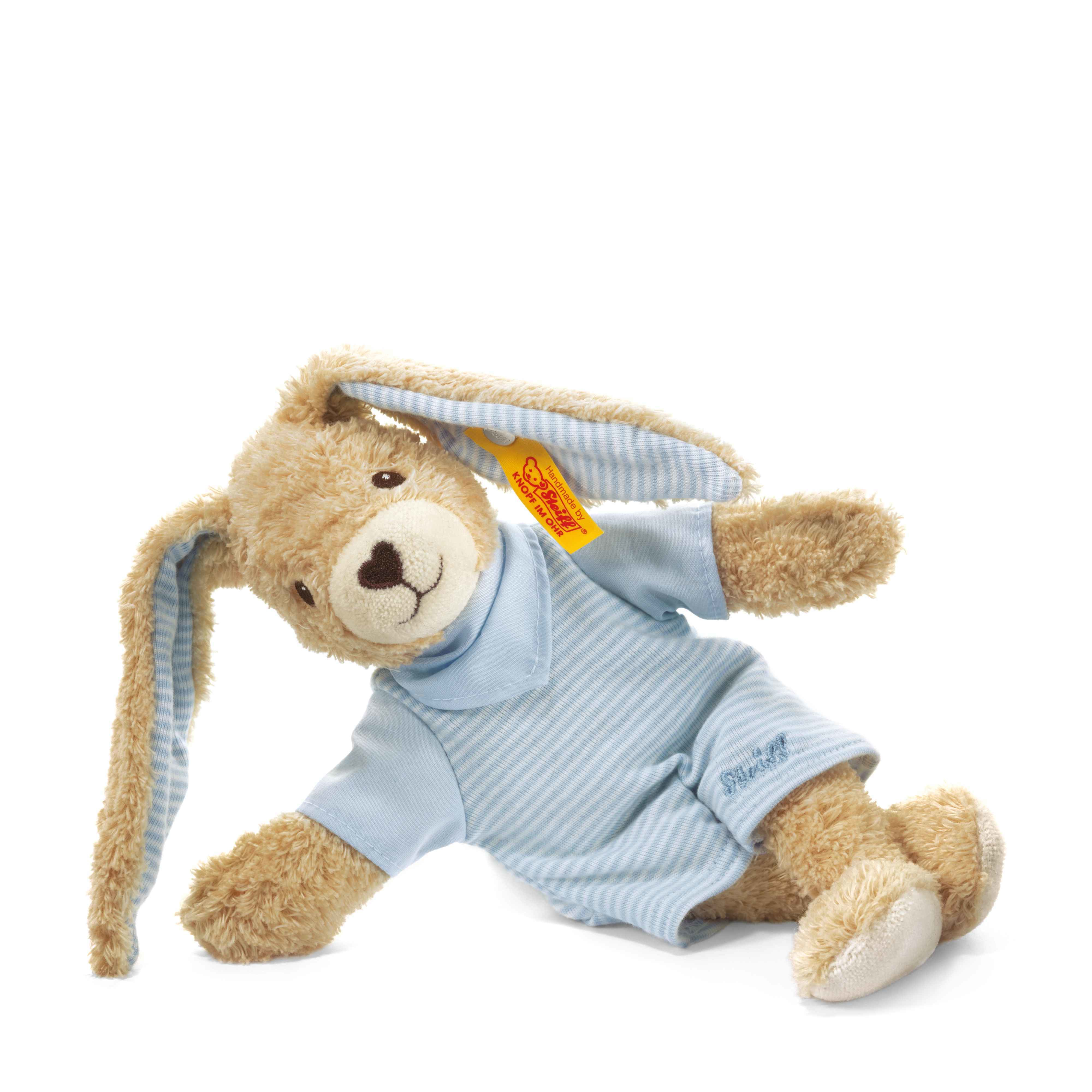 Un coniglio di peluche beige con un completo a righe blu, sdraiato su sfondo bianco.
