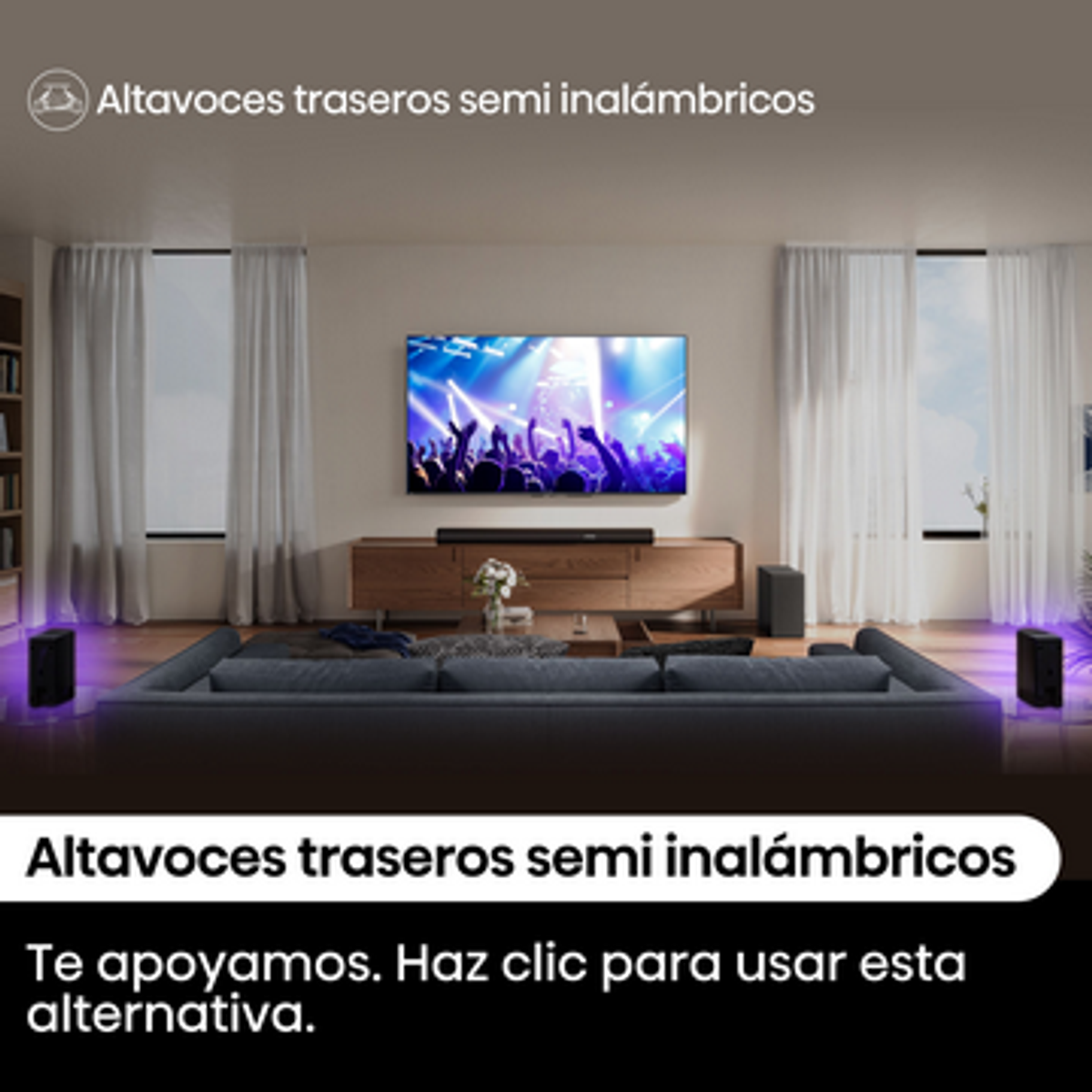 Salón con un gran televisor mostrando un concierto. Hay altavoces y un sofá gris. Se ven cortinas y ventanas.