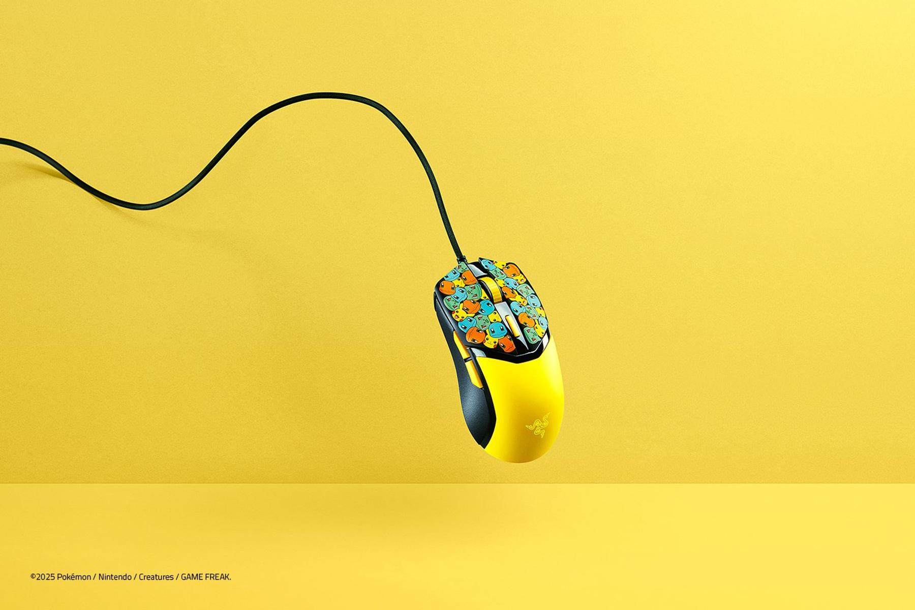 Un mouse Razer Pokemon giallo e nero con cavo nero su sfondo giallo. Il mouse ha personaggi Pokemon.