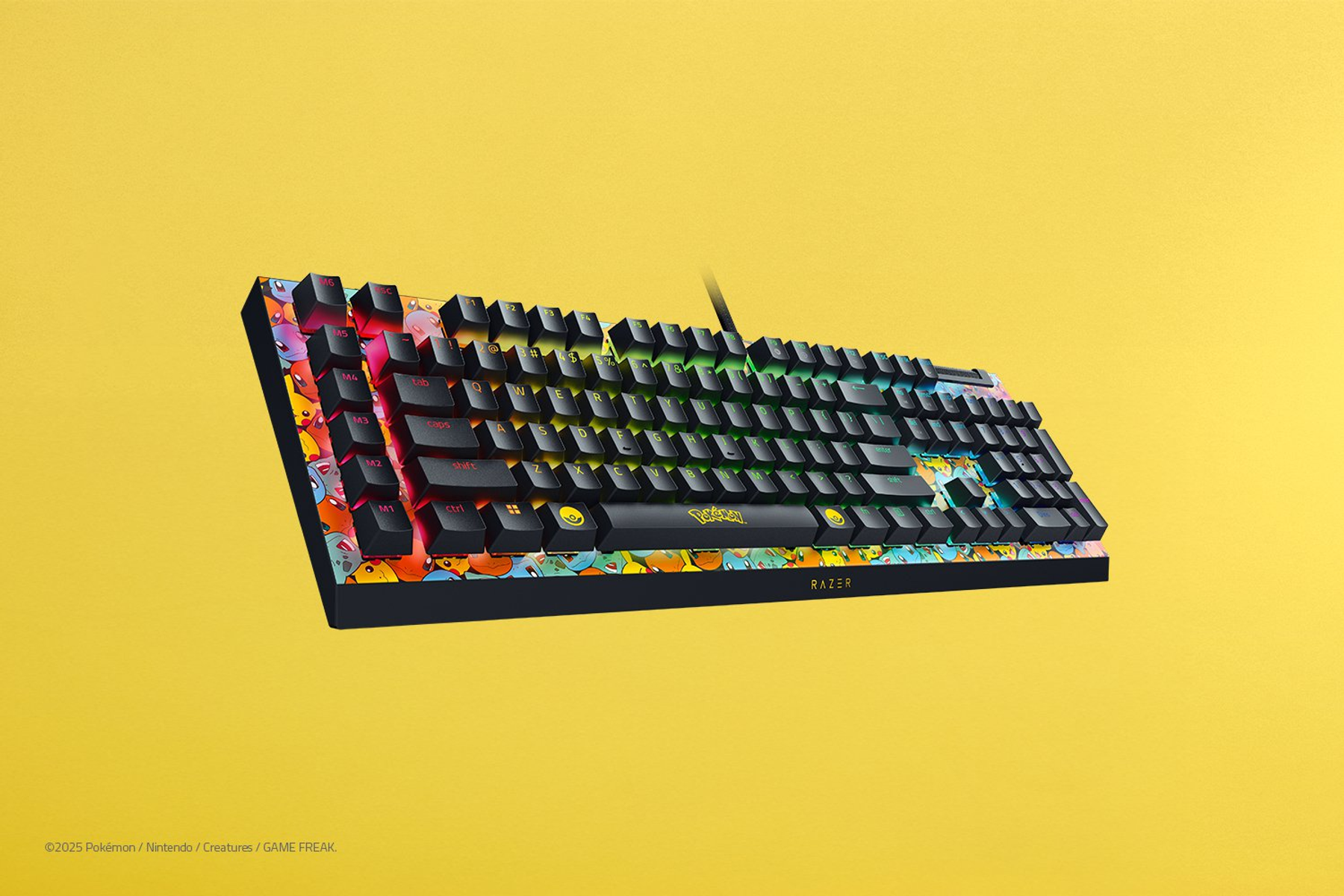 Klawiatura Razer Pokemon z czarnymi klawiszami i kolorowymi wzorami Pokemon na krawędziach, na żółtym tle.