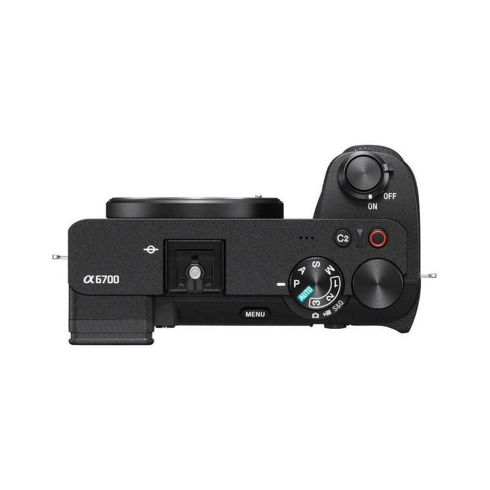 A black Sony Alpha 6700 camera is shown from above. It has a lens, dials, buttons, and a mode selector. The power switch is on.