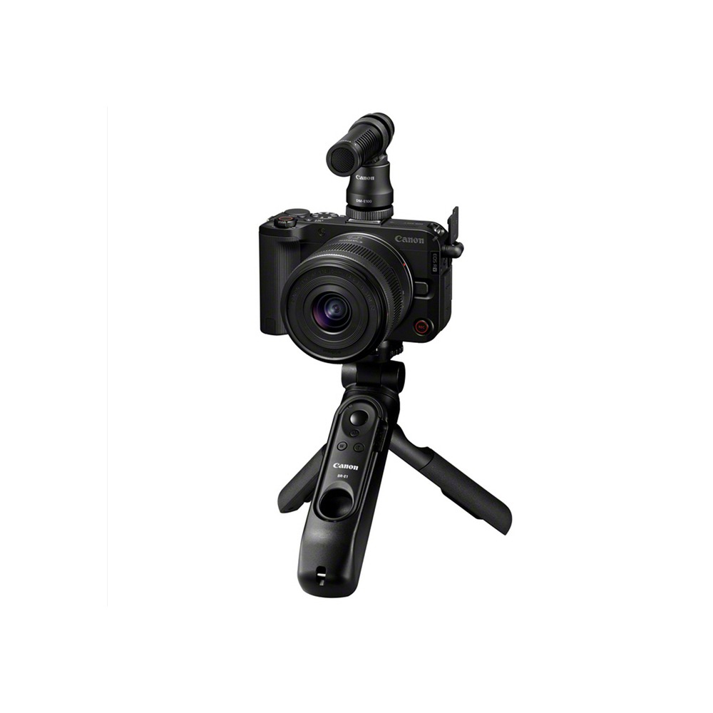 Una fotocamera Canon nera con un microfono montato su un treppiede. L'obiettivo della fotocamera è rivolto verso l'osservatore.
