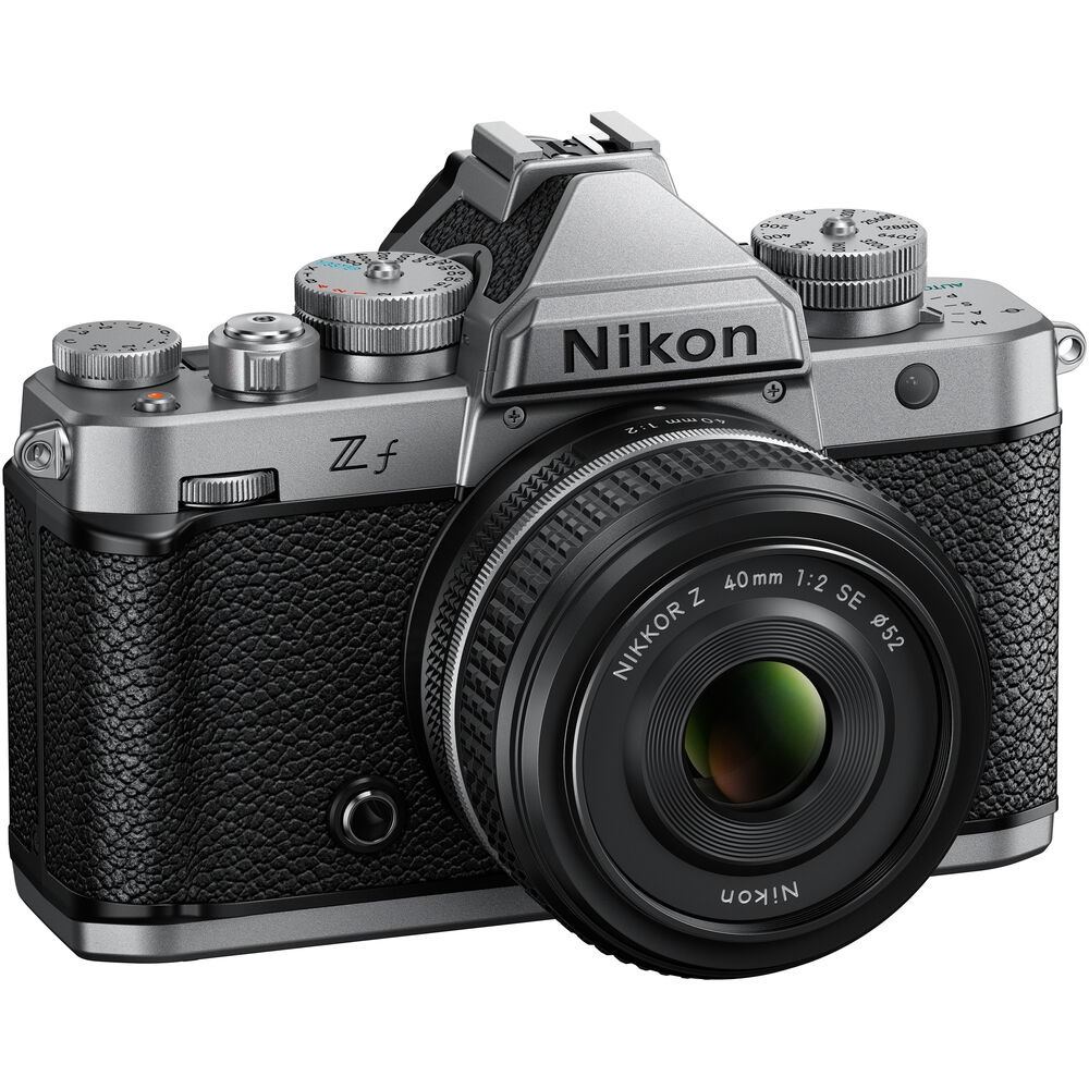 Una cámara Nikon Zf plateada y negra con lente. La lente dice Nikkor Z 40mm 1:2 SE. La cámara tiene diales y botones.