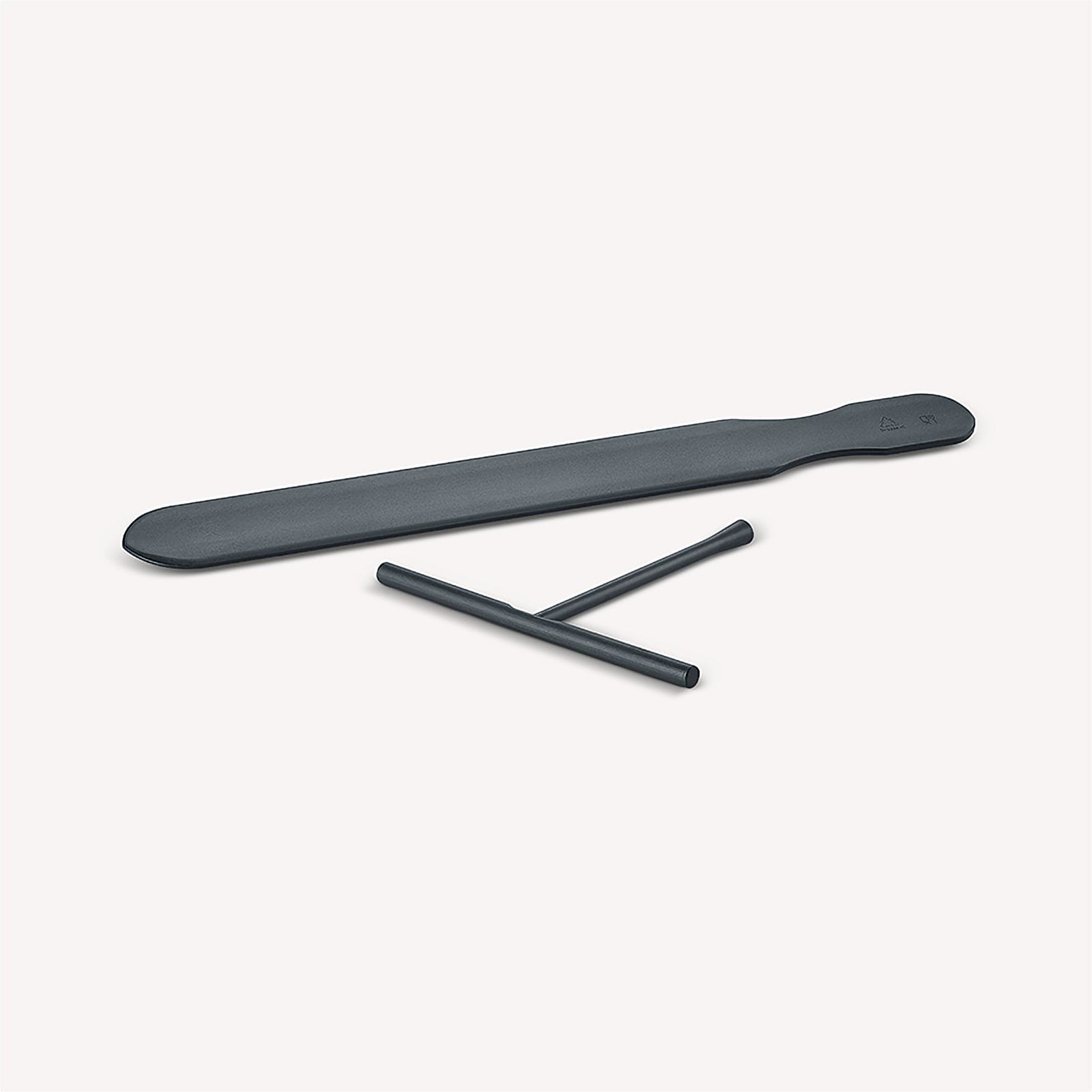 Ciemnoszare narzędzia kuchenne na białej powierzchni. Długa szpatułka i małe narzędzie w kształcie litery T.
