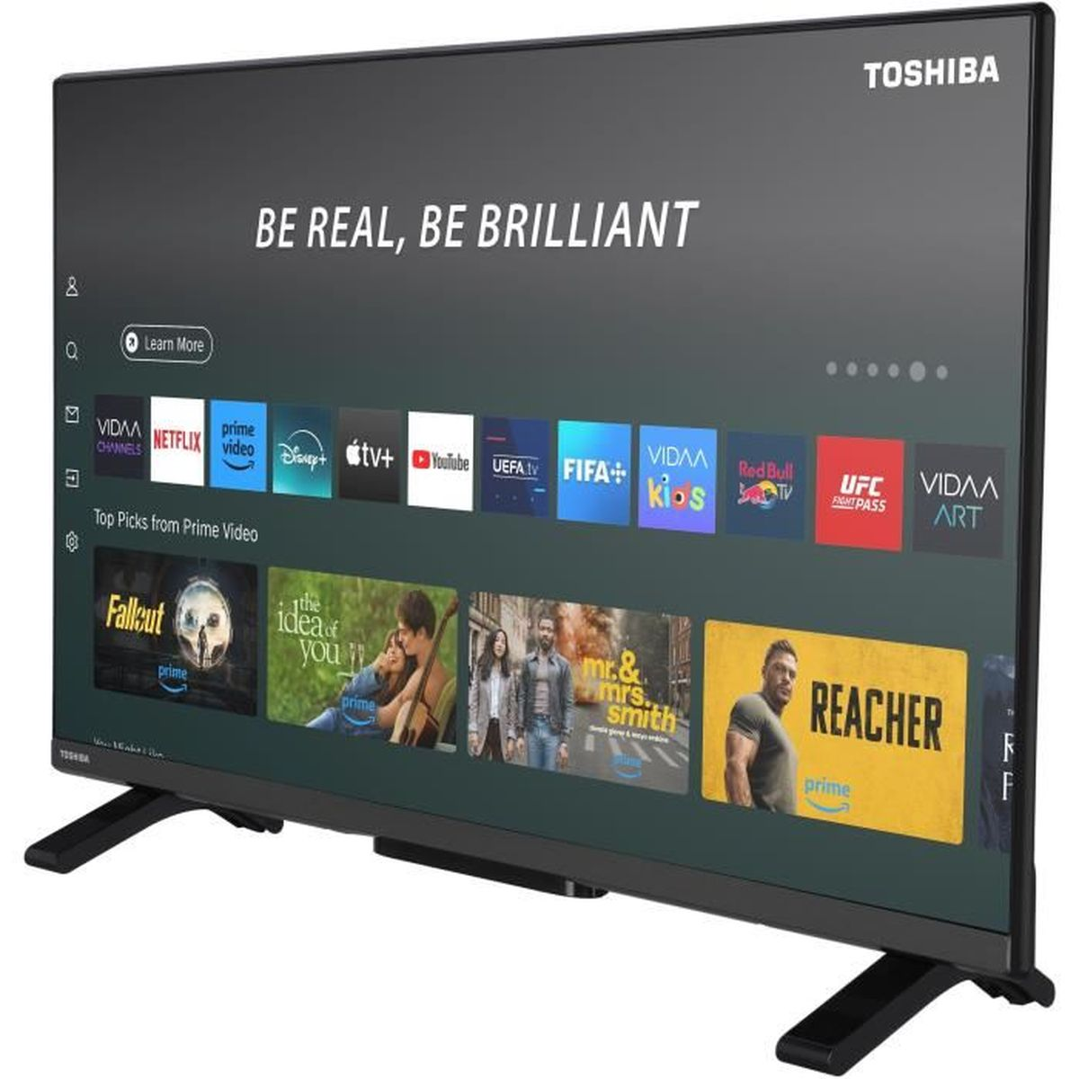 Un televisor Toshiba que muestra una interfaz de Smart TV. Muestra iconos de aplicaciones como Netflix, Prime Video y YouTube. La pantalla muestra 'BE REAL, BE BRILLIANT'.