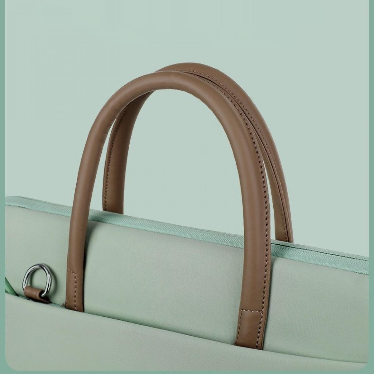 Nahaufnahme einer hellgrünen Laptoptasche mit braunen Ledergriffen und einem silbernen Metallring auf hellgrünem Hintergrund.