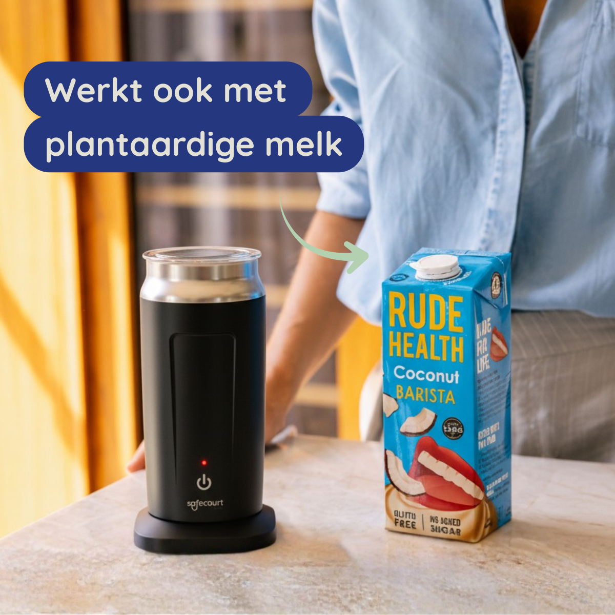 Een zwart apparaat met een rood lampje, een pak kokosmelk en tekst die compatibiliteit met plantaardige melk aangeeft.