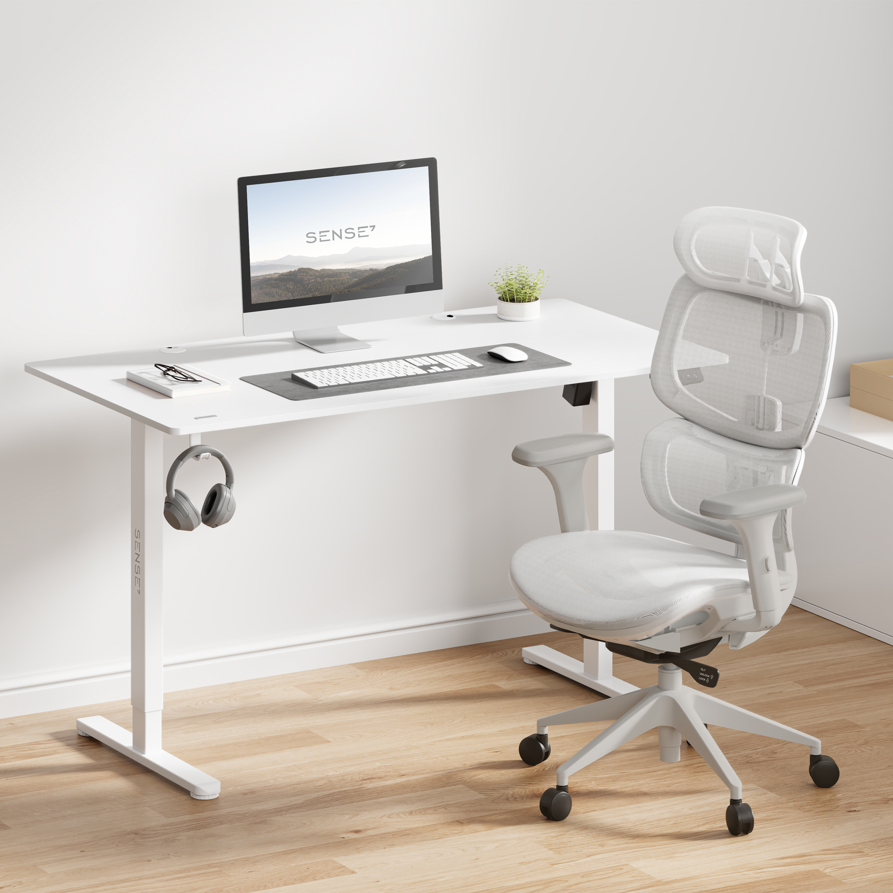 Een witte bureau met een computer en een witte ergonomische stoel. Een koptelefoon hangt eraan.