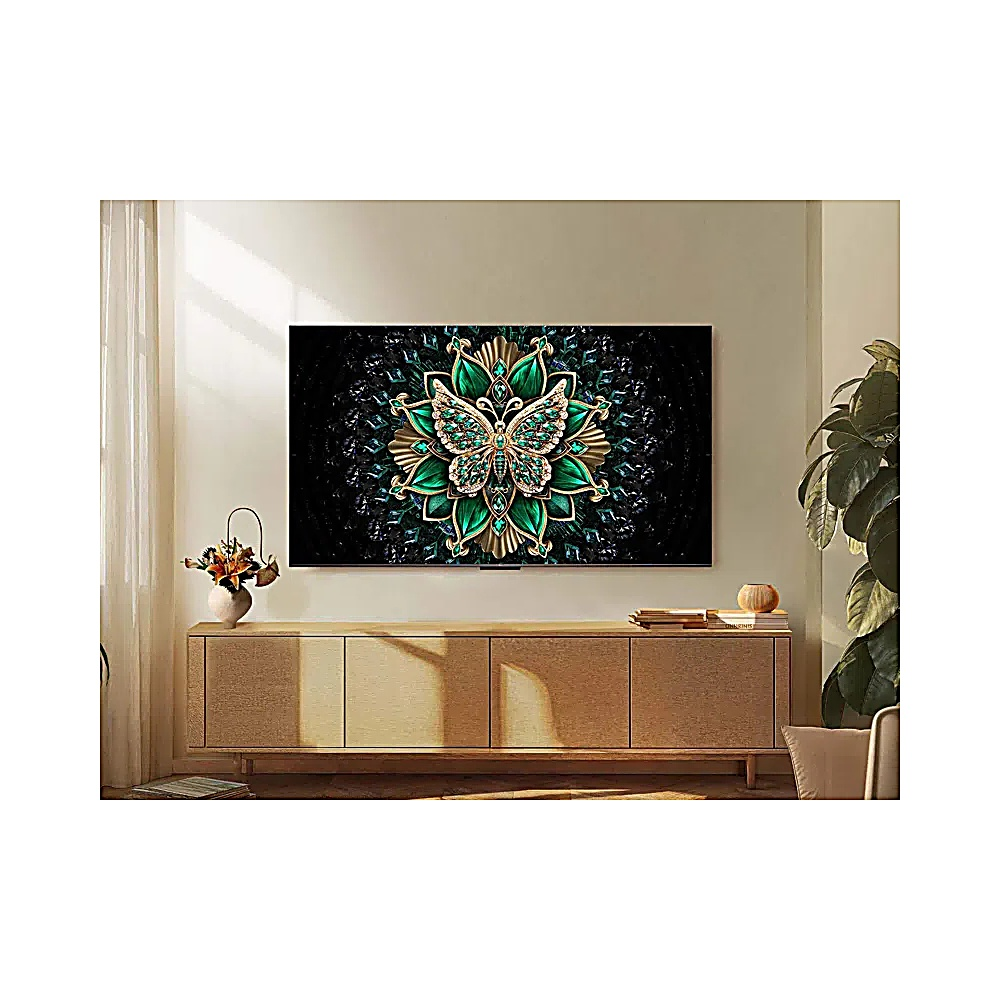 Un televisore mostra un'arte di farfalla verde e oro. È sopra un mobile in legno. Sono presenti una pianta e un vaso con fiori.