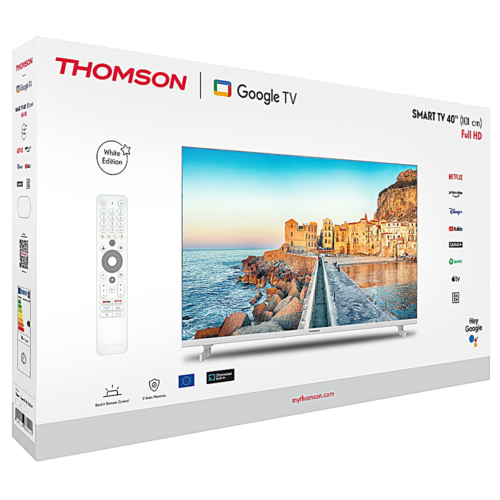 Scatola bianca Smart TV Thomson. La TV mostra una scena di città costiera. Telecomando e logo Google TV visibili.