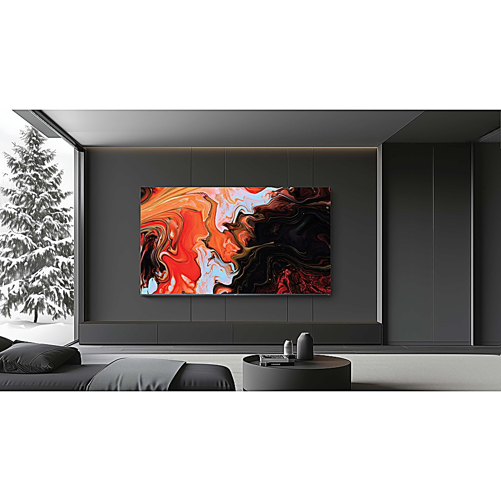 Salón moderno con TV grande mostrando arte abstracto. Escena invernal nevada visible a través de una ventana grande.
