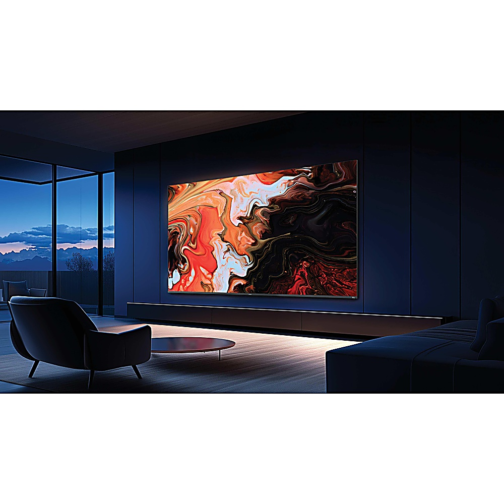 Salón con gran televisor que muestra arte abstracto. Cuenta con sofá, sillón y mesa de centro redonda. La habitación tiene paredes azul oscuro.