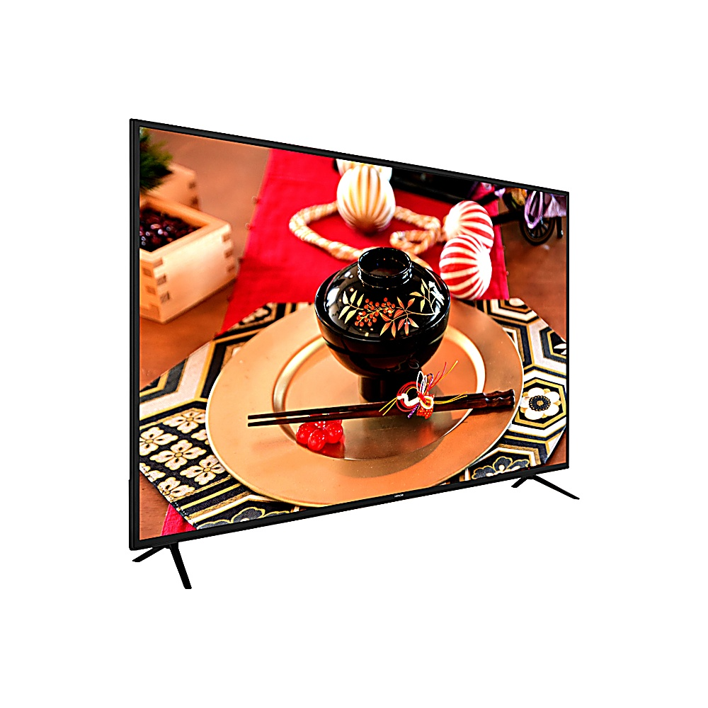 Un televisor muestra una comida japonesa: cuenco negro con diseño dorado sobre plato dorado, palillos, bayas rojas y elementos decorativos sobre tela roja.