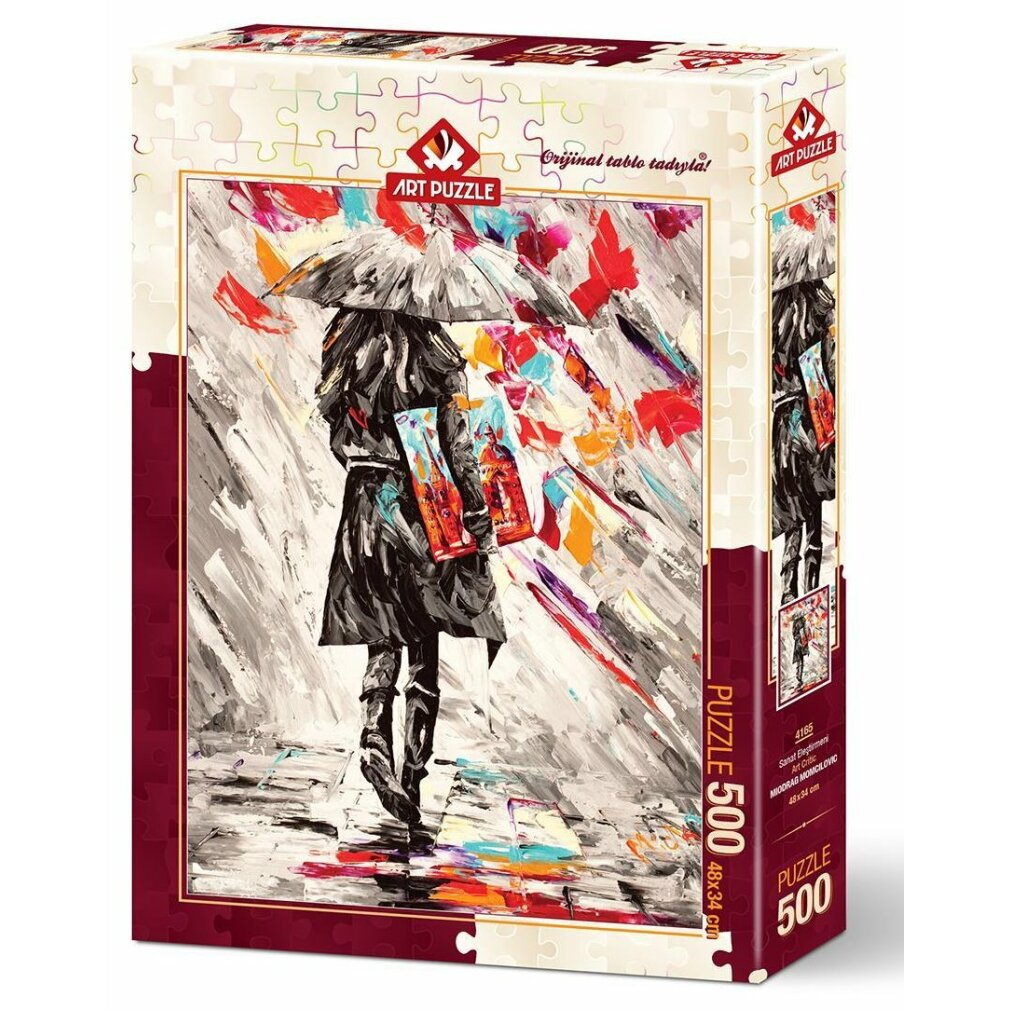 Una scatola di puzzle mostra una persona che cammina sotto la pioggia con un ombrello. Lo stile è impressionista con pennellate colorate.
