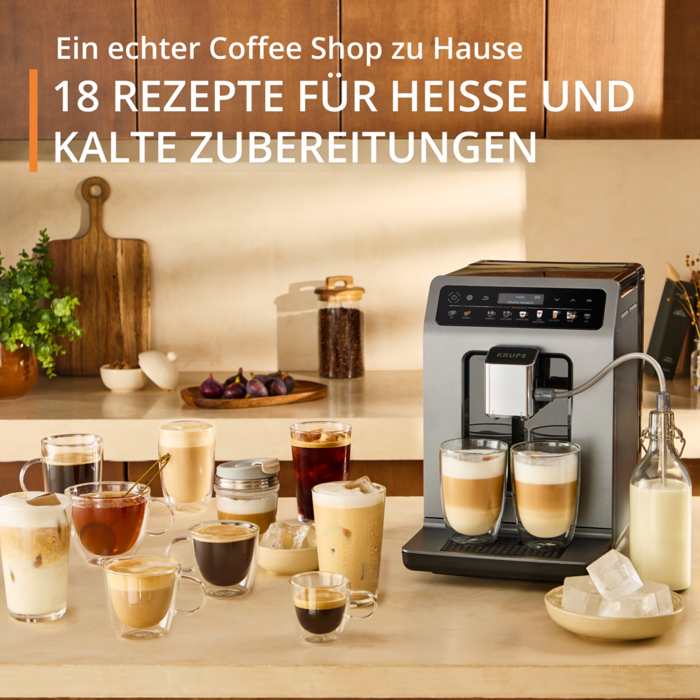 Macchina da caffè con bevande al caffè, cubetti di ghiaccio e bottiglia di latte. Varie tazze di caffè e un tagliere sono sul tavolo.