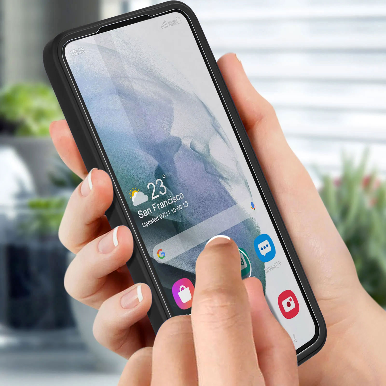 Una mano tiene un telefono, un dito tocca lo schermo. Schermo mostra info meteo, app. Custodia nera, unghie bianche, sfondo sfocato.