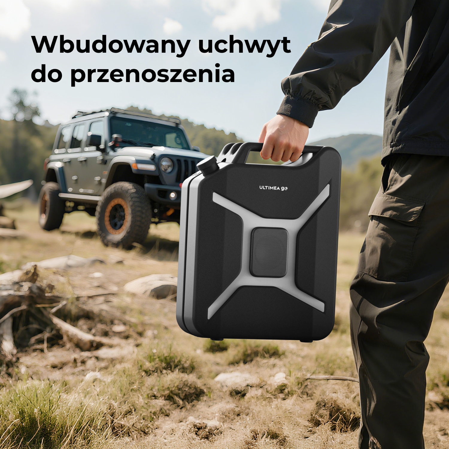 Osoba trzyma czarny głośnik z uchwytem, ​​przed jeepem. Głośnik jest oznaczony "ULTIMEA go". Tło jest na zewnątrz.