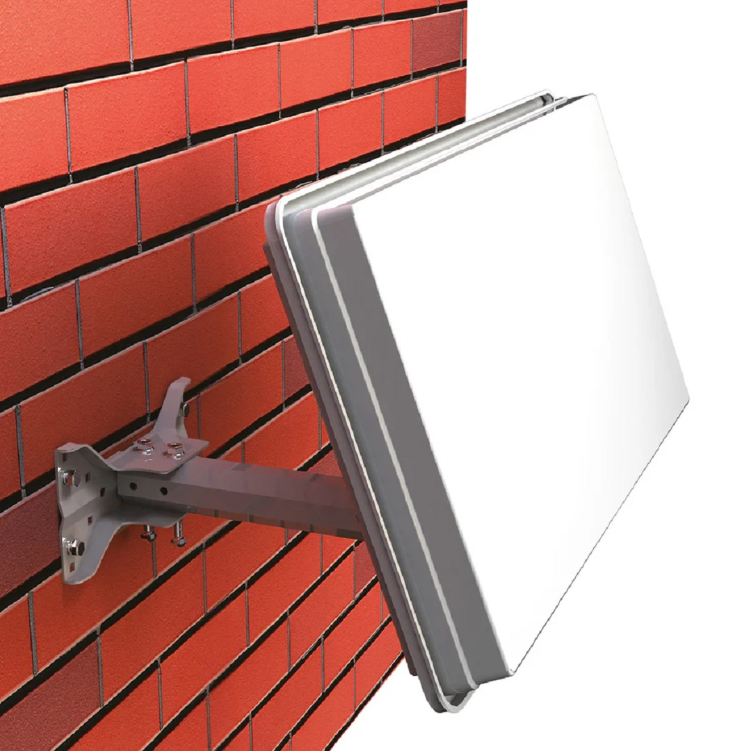 Una antena parabólica rectangular blanca está montada en una pared de ladrillo rojo con un soporte de metal.