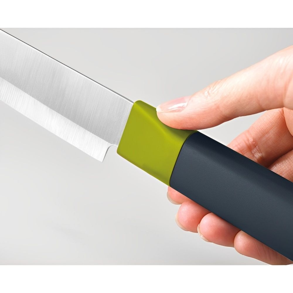 Una mano sostiene un cuchillo. El cuchillo tiene una hoja plateada, mango verde y gris. El fondo es blanco.