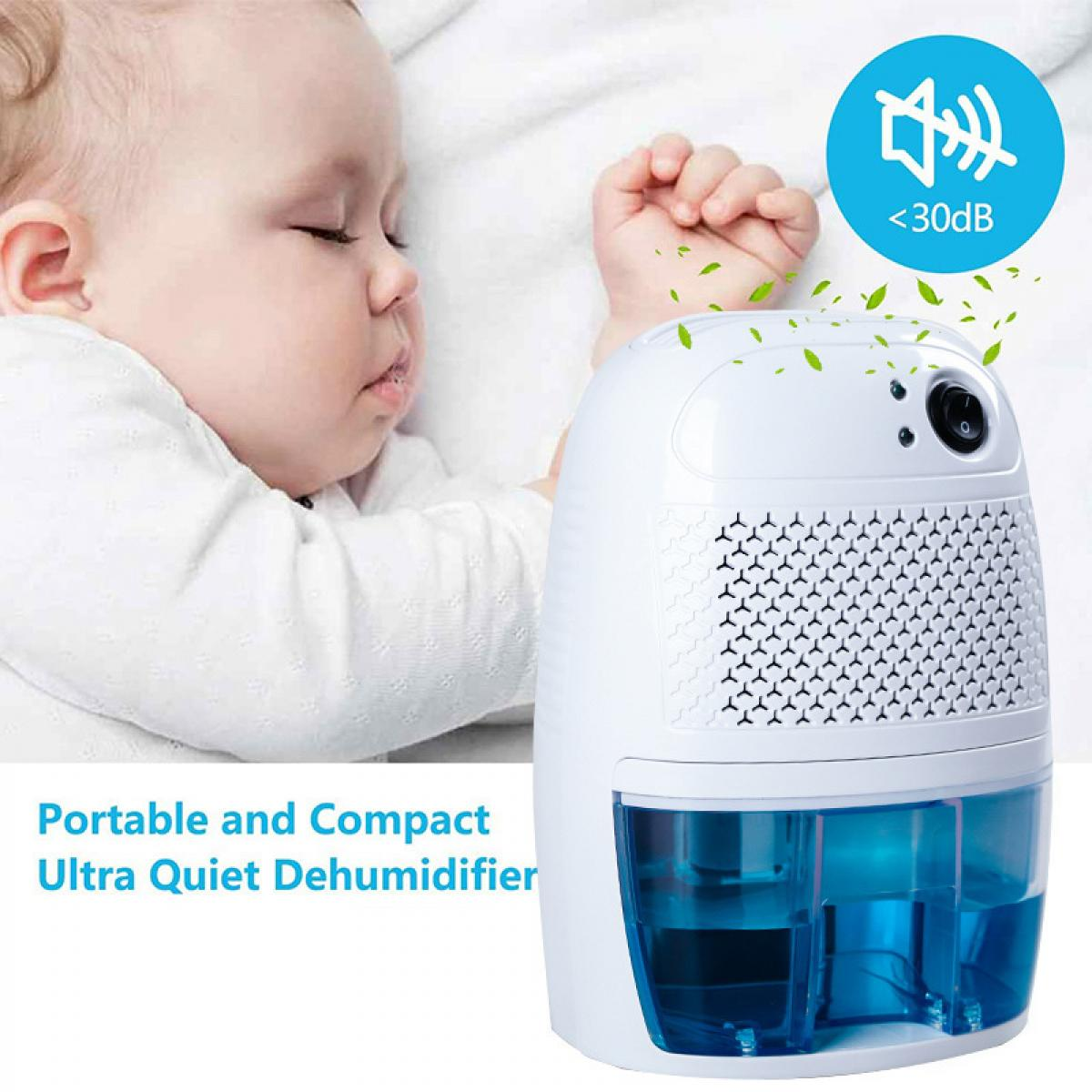 Ein schlafendes Baby und ein weißer Luftentfeuchter mit blauem Wassertank. Das Gerät ist als ultra leise gekennzeichnet.