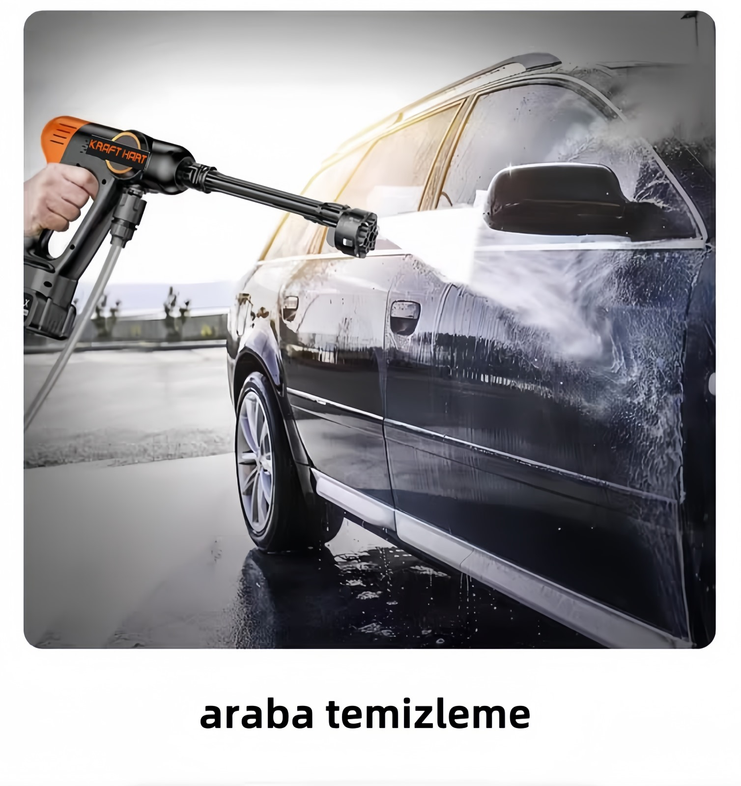 Bir kişi siyah bir arabayı basınçlı yıkama makinesiyle yıkıyor. Yıkama makinesi turuncu ve siyahtır, arabaya su püskürtüyor.