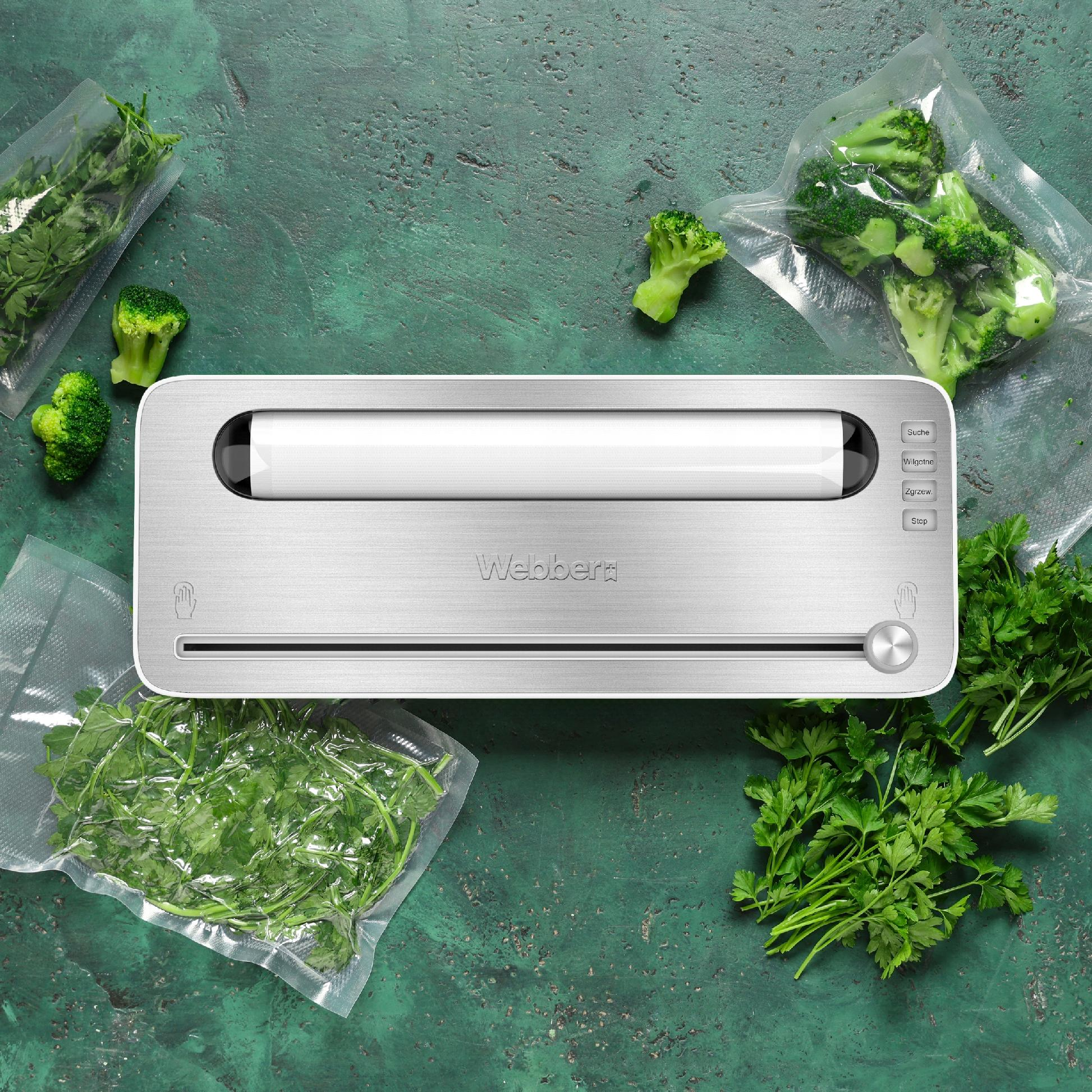 Srebrna zgrzewarka do żywności z pietruszką i brokułami. Niektóre warzywa są w zamkniętych workach. Zielona powierzchnia.
