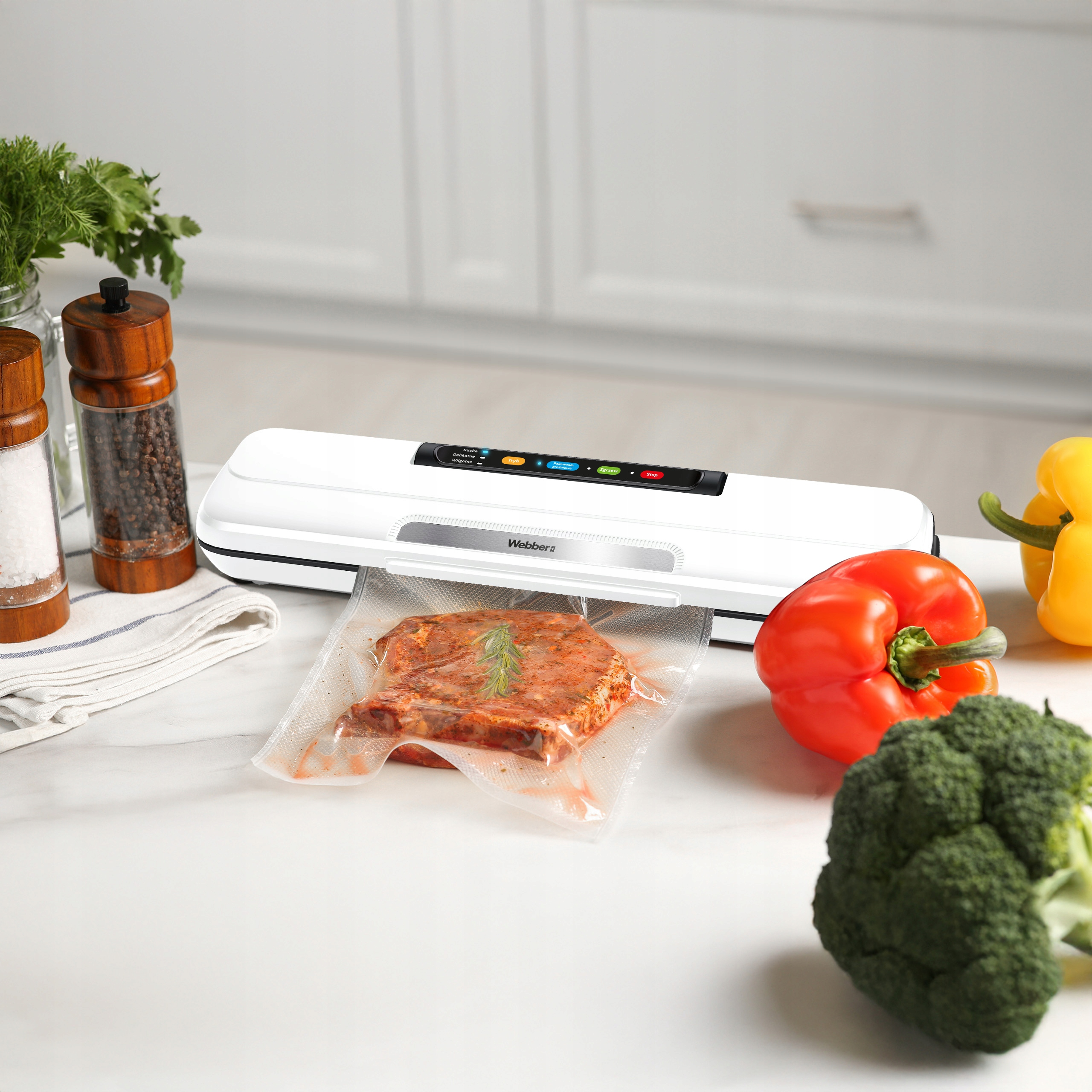 Biała zgrzewarka próżniowa ze stekiem w worku, czerwoną papryką, brokułami, solą, pieprzem i ziołami.