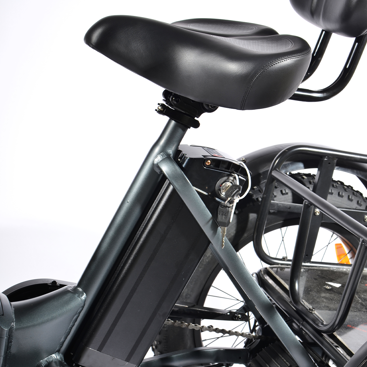 Zbliżenie czarnego siodełka i ramy roweru elektrycznego. Widoczny jest również akumulator, bagażnik i klucz. Białe tło.