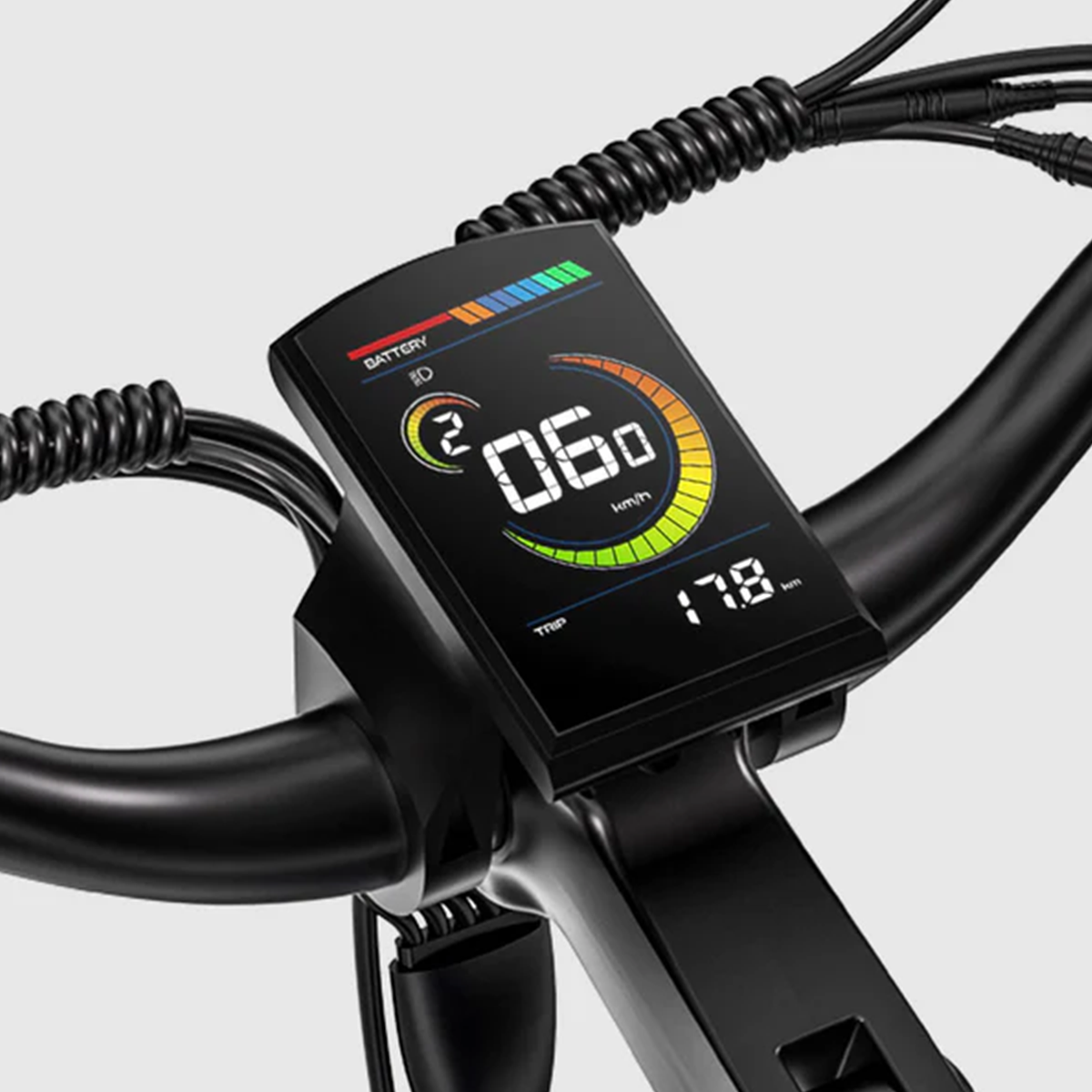 Zbliżenie wyświetlacza roweru elektrycznego pokazujące prędkość 60 km/h, poziom baterii i przebieg. Czarne kierownice i kable.